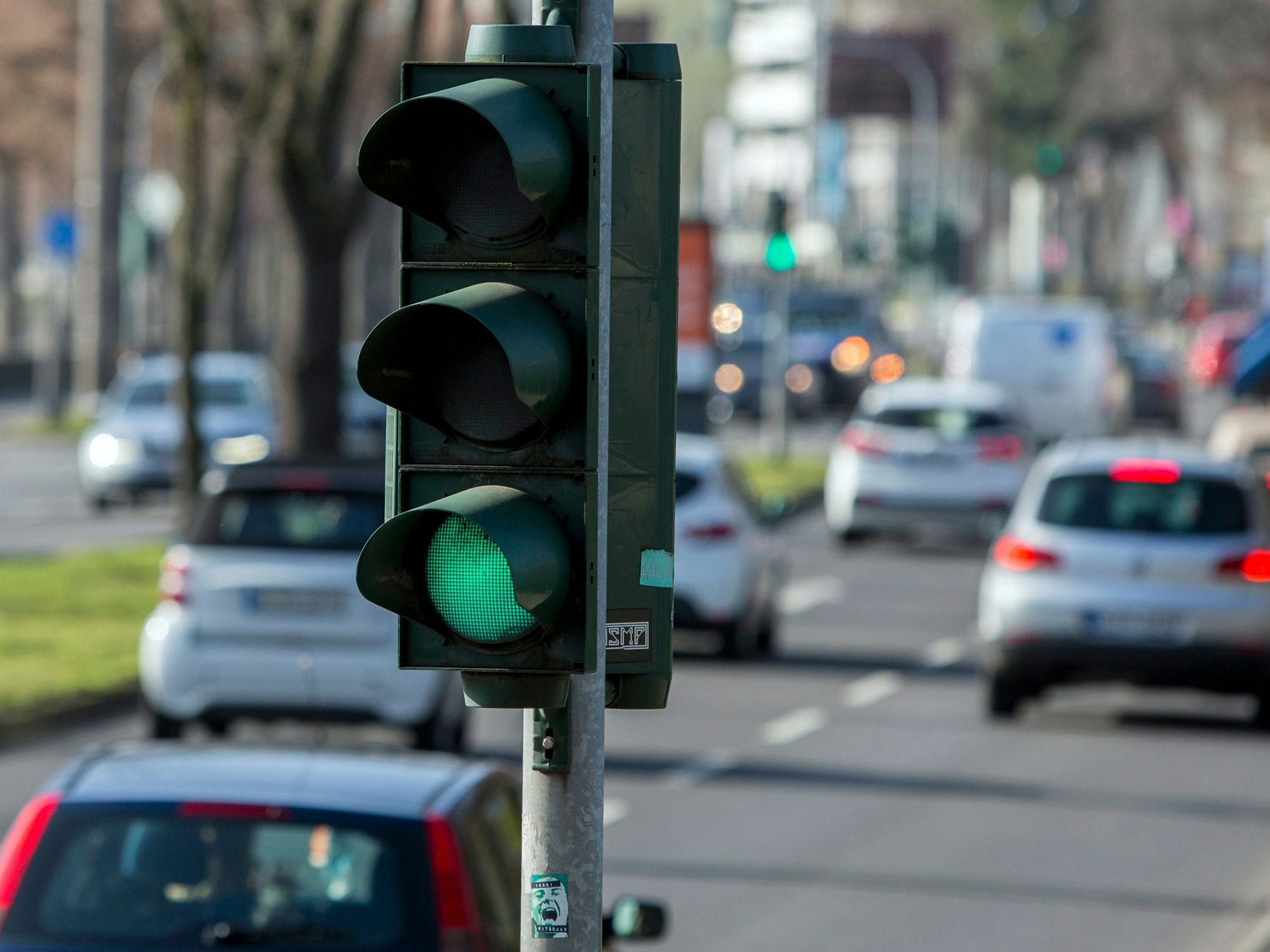 Eine Ampel in Köln, im Hintergrund der rollende Verkehr.