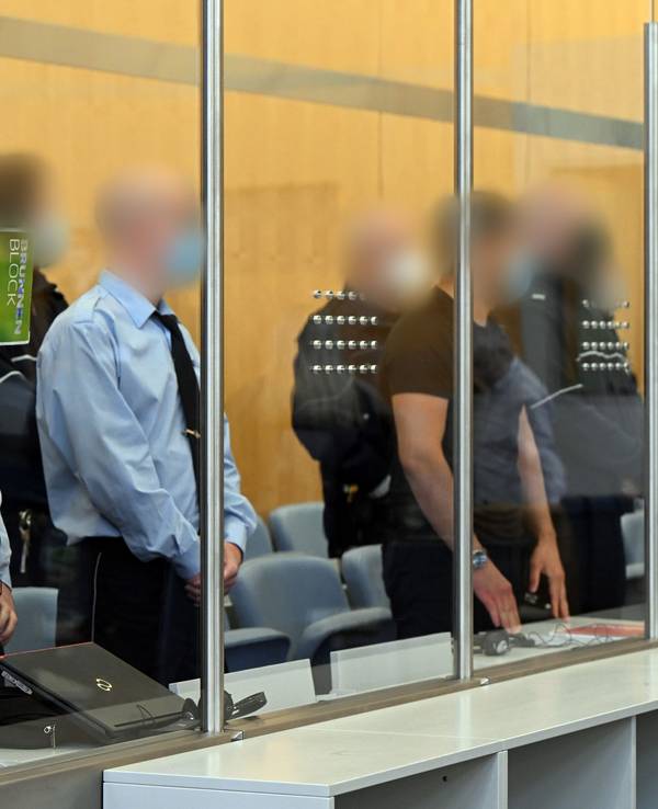 Die Angeklagten warten im Gerichtsaal auf den Beginn der Verhandlung.