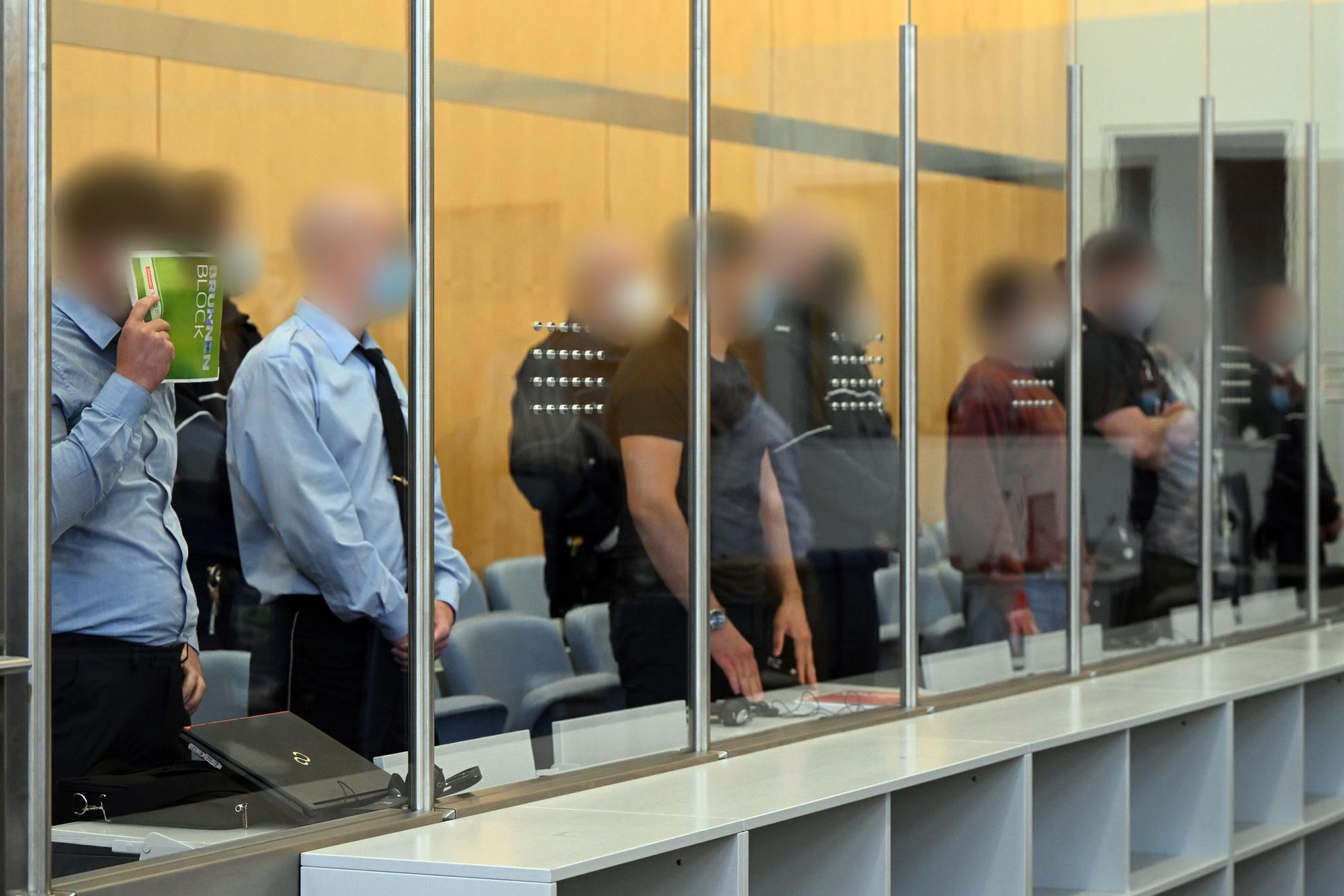 Die Angeklagten warten im Gerichtsaal auf den Beginn der Verhandlung.
