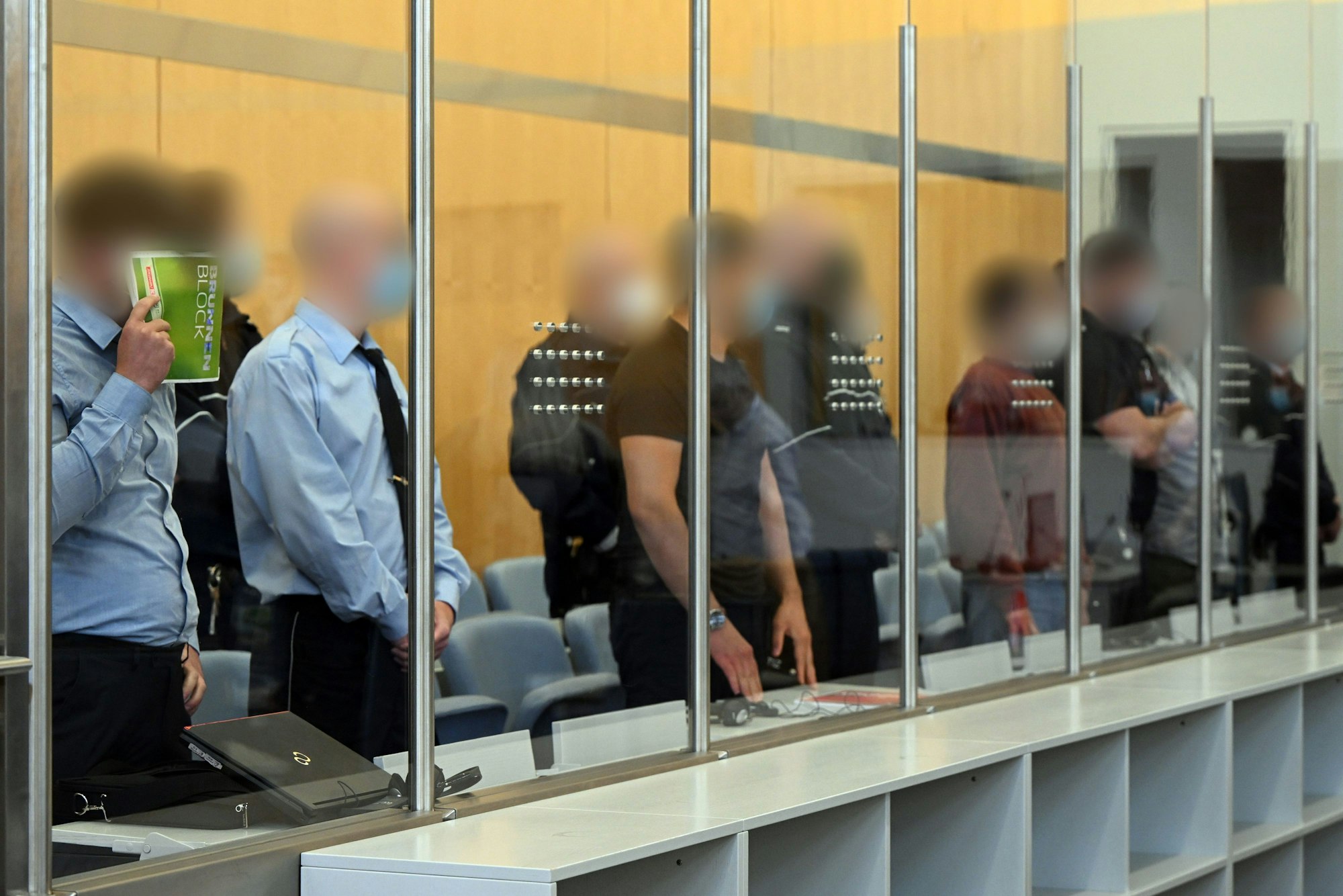 Die Angeklagten warten im Gerichtsaal auf den Beginn der Verhandlung.