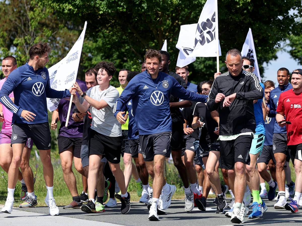 Die Nationalspieler laufen mit Adidas-Mitarbeitenden im DFB-Camp.
