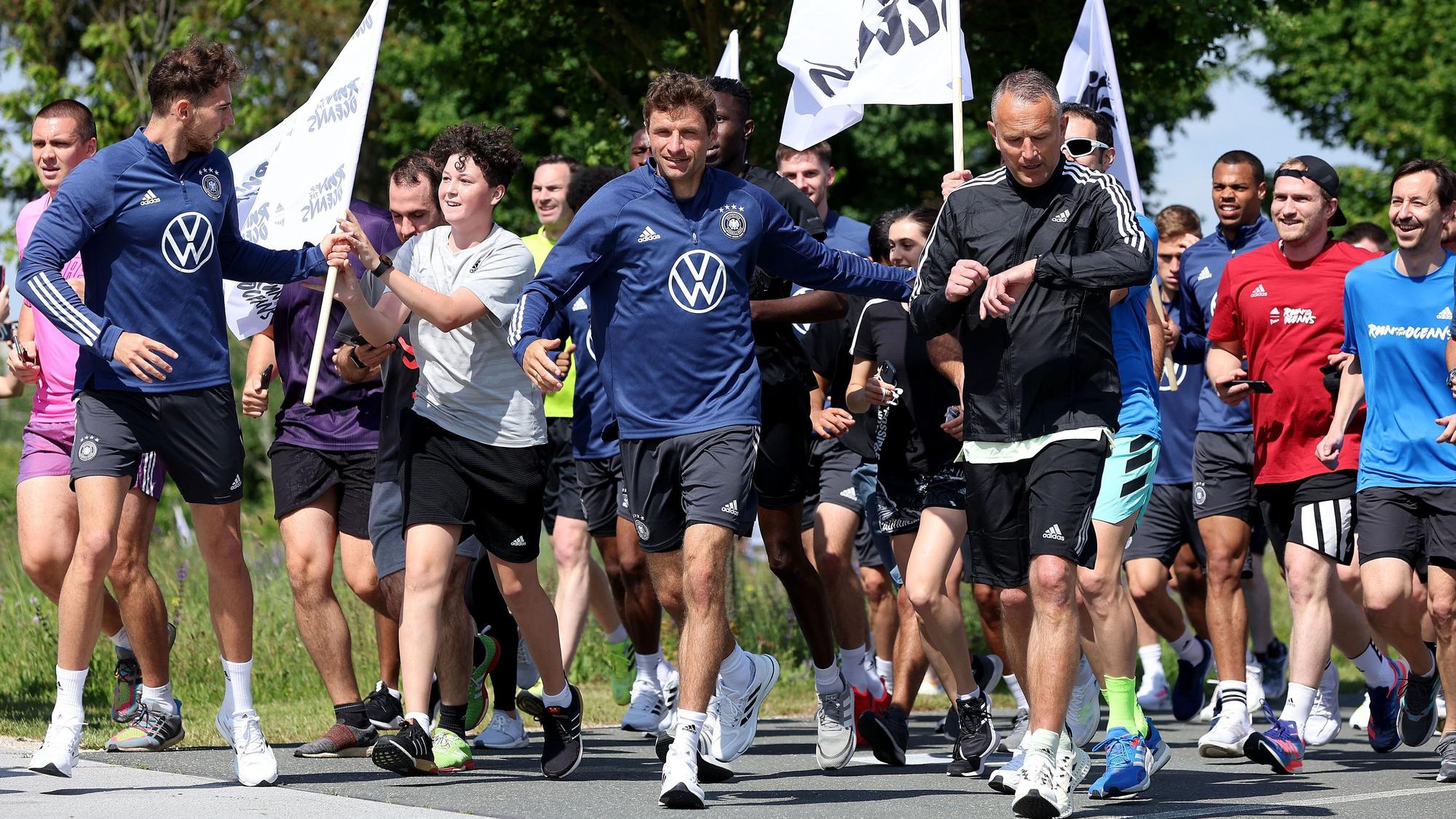 Die Nationalspieler laufen mit Adidas-Mitarbeitenden im DFB-Camp.