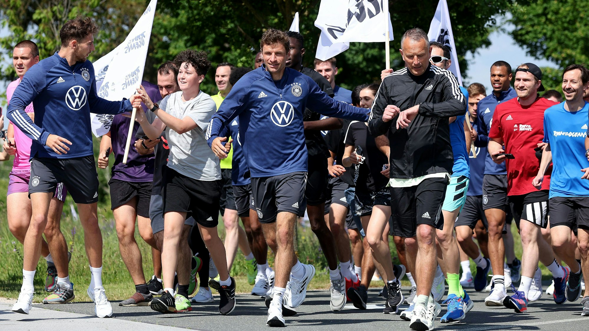 Die Nationalspieler laufen mit Adidas-Mitarbeitenden im DFB-Camp.