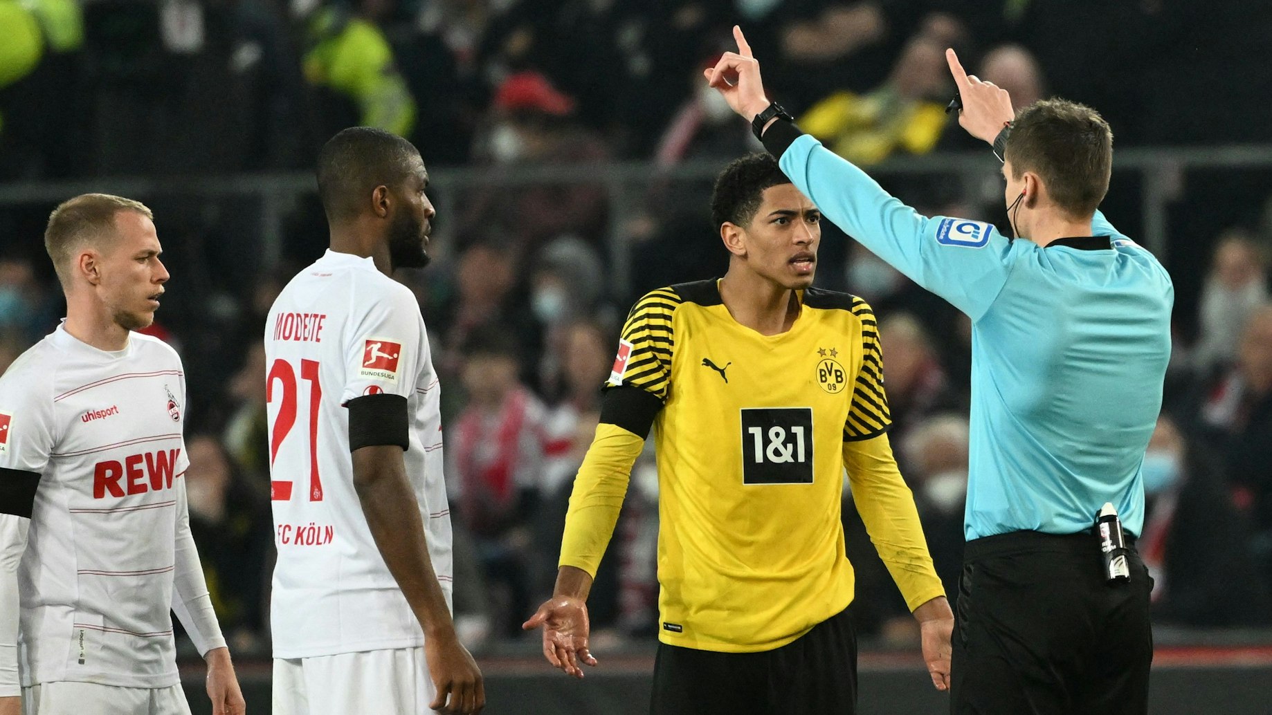 Jude Bellinham beschwert sich im Spiel von Borussia Dortmund beim 1. FC Köln beim Schiedsrichter Daniel Siebert.