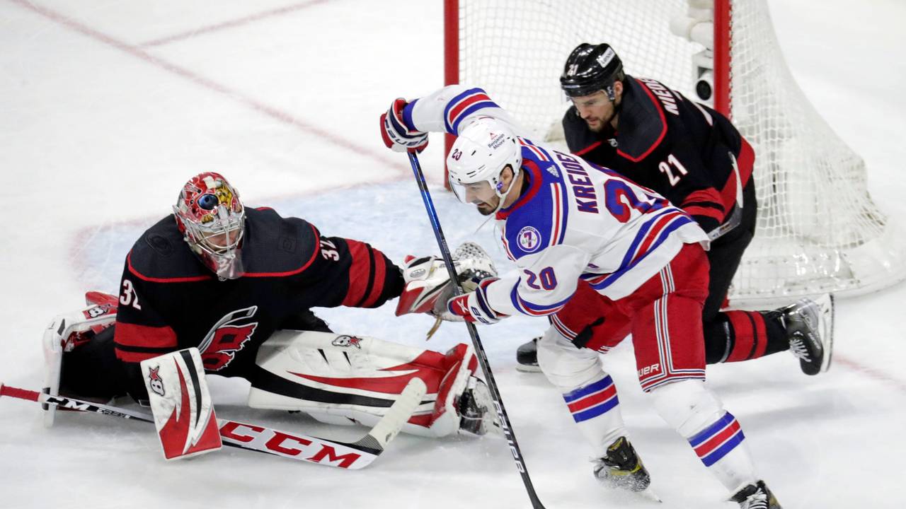 Chris Kreider (M, 20) von den New York Rangers in Aktion gegen Torwart Antti Raanta (32) und Nino Niederreiter (r, 21) von den Carolina Hurricanes.