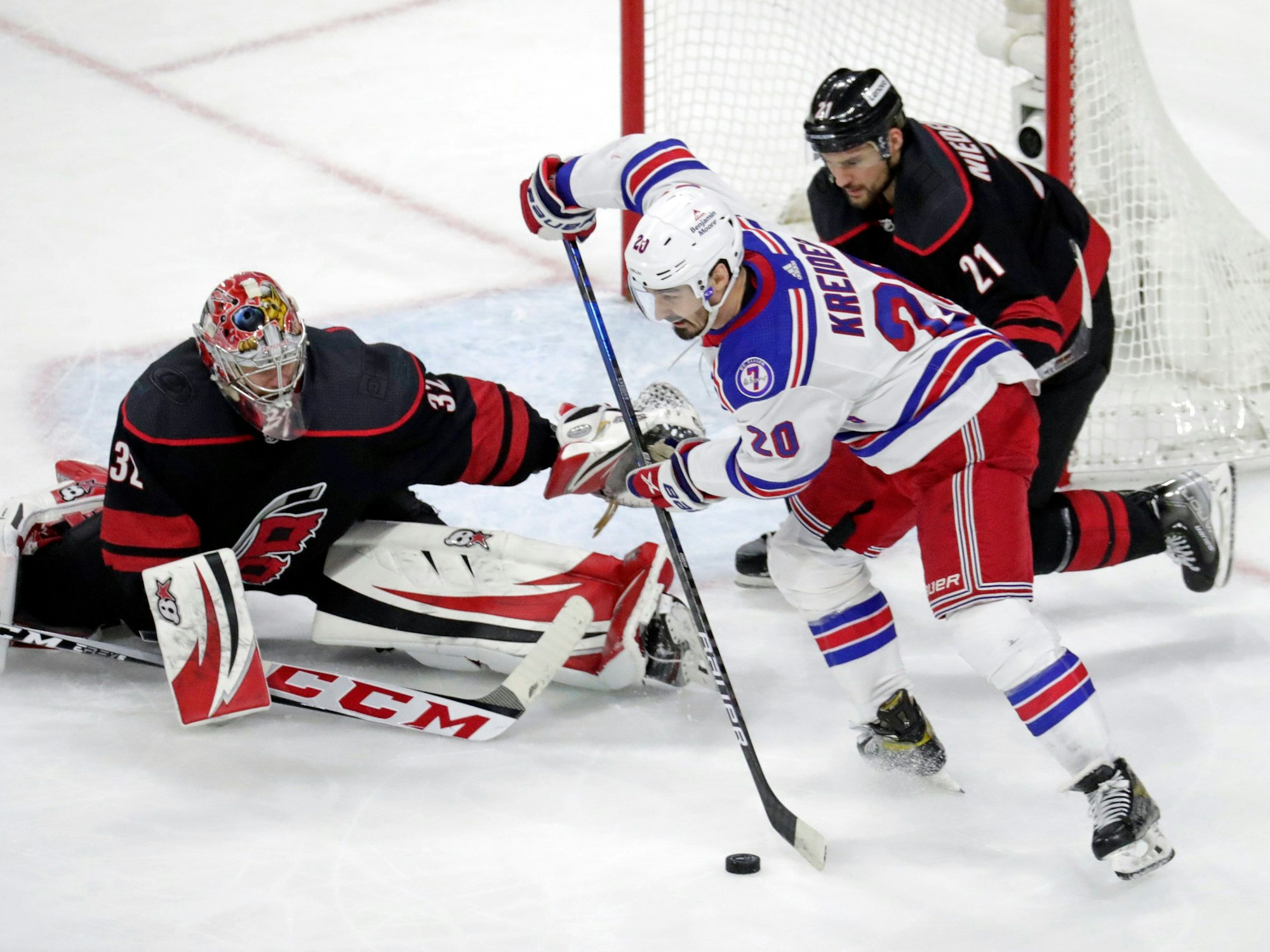 Chris Kreider (M, 20) von den New York Rangers in Aktion gegen Torwart Antti Raanta (32) und Nino Niederreiter (r, 21) von den Carolina Hurricanes.
