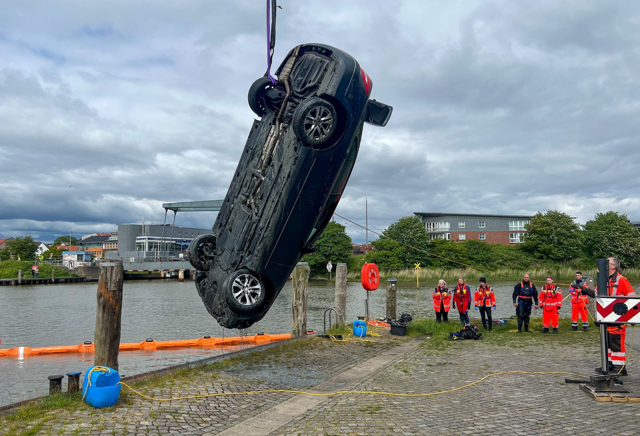 Einsatzkräfte ziehen am Montag (30. Mai) mit einem Kran ein Auto aus dem Husumer Hafenbecken. Beide Insassen starben bei dem Unfall.