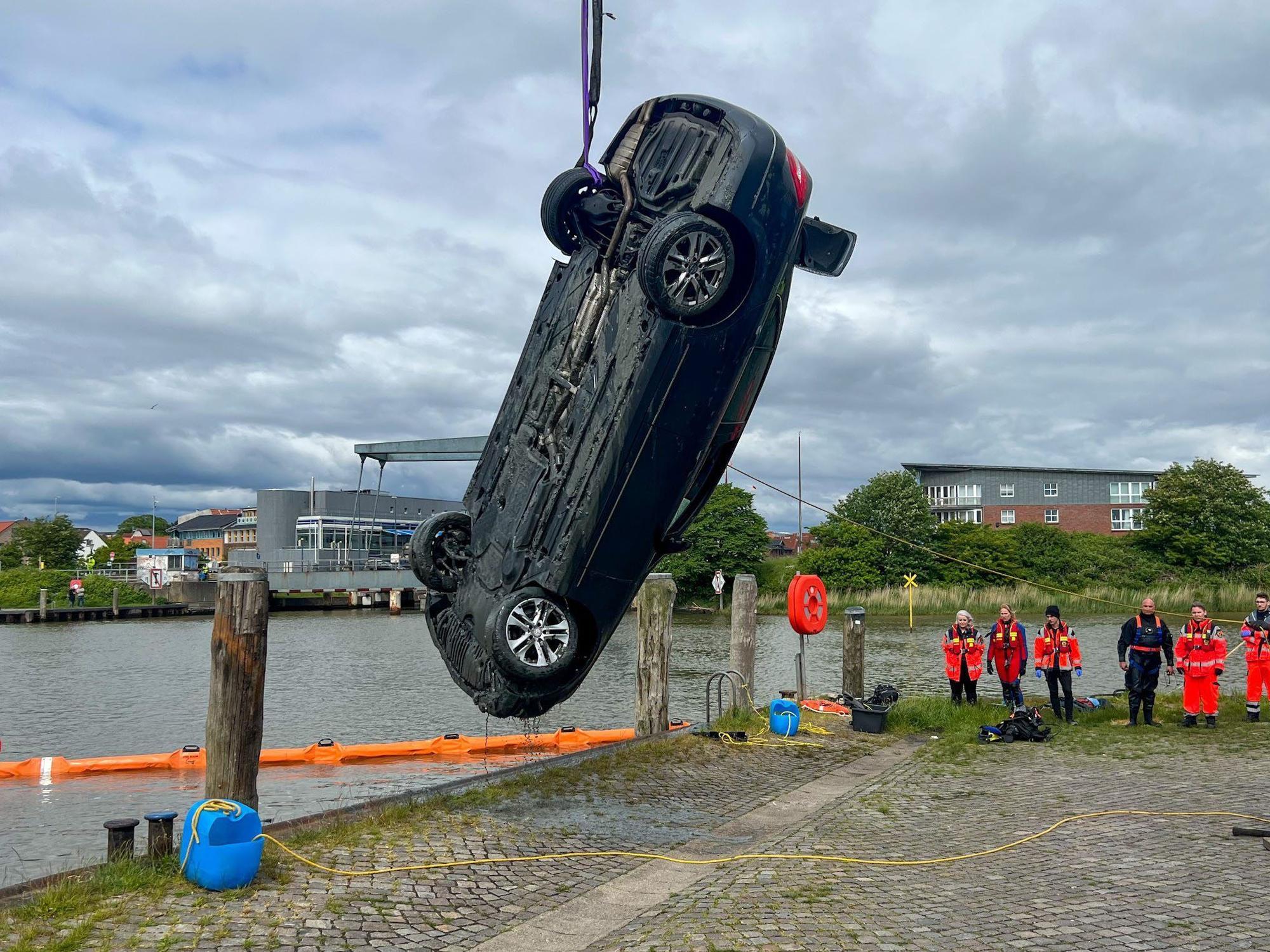 Einsatzkräfte ziehen am Montag (30. Mai) mit einem Kran ein Auto aus dem Husumer Hafenbecken. Beide Insassen starben bei dem Unfall.