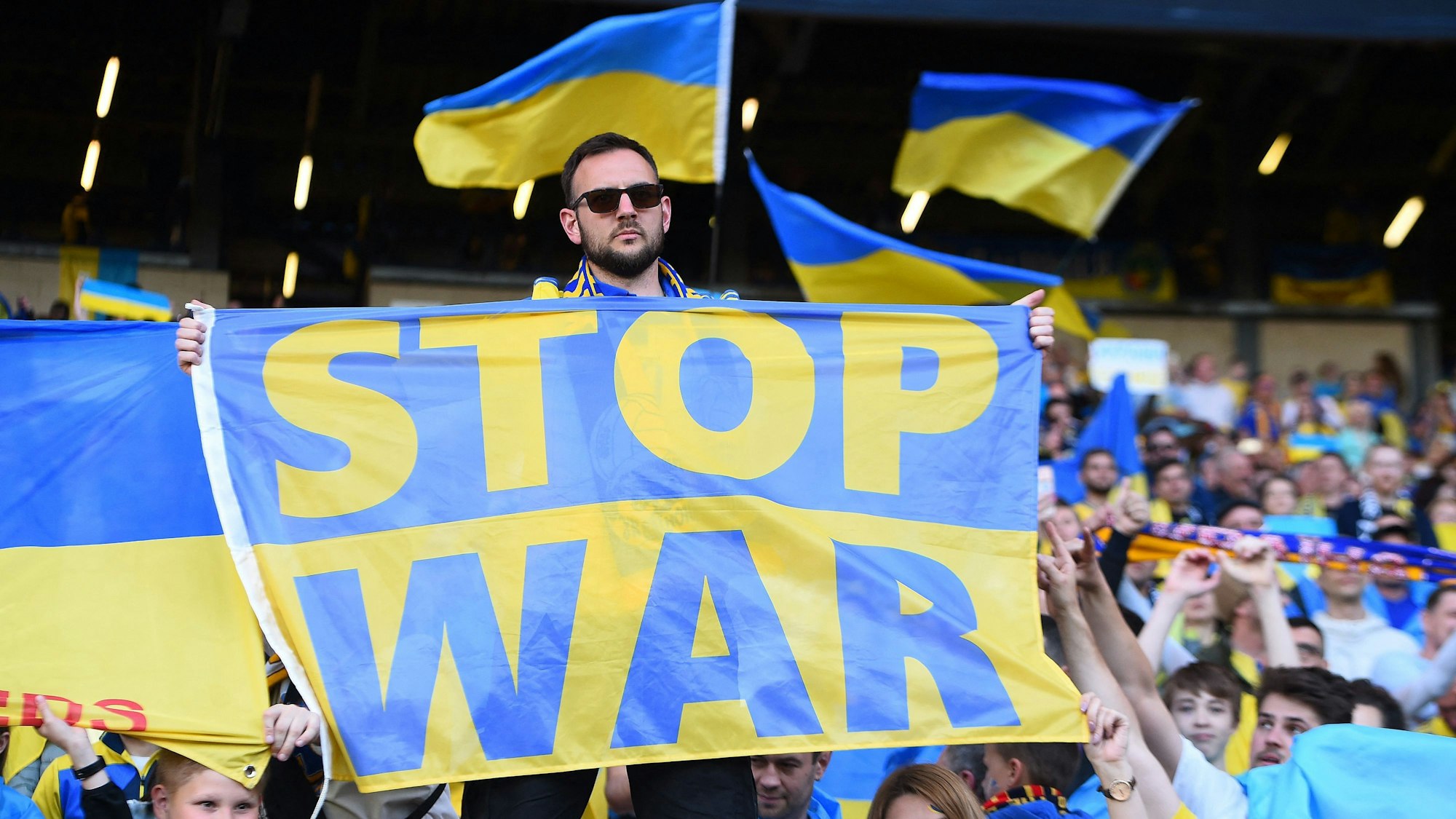 Ein Fan hält ein Banner mit der Aufschrift „Stop War“ beim Playoff-Halbfinale Schottland gegen Ukraine