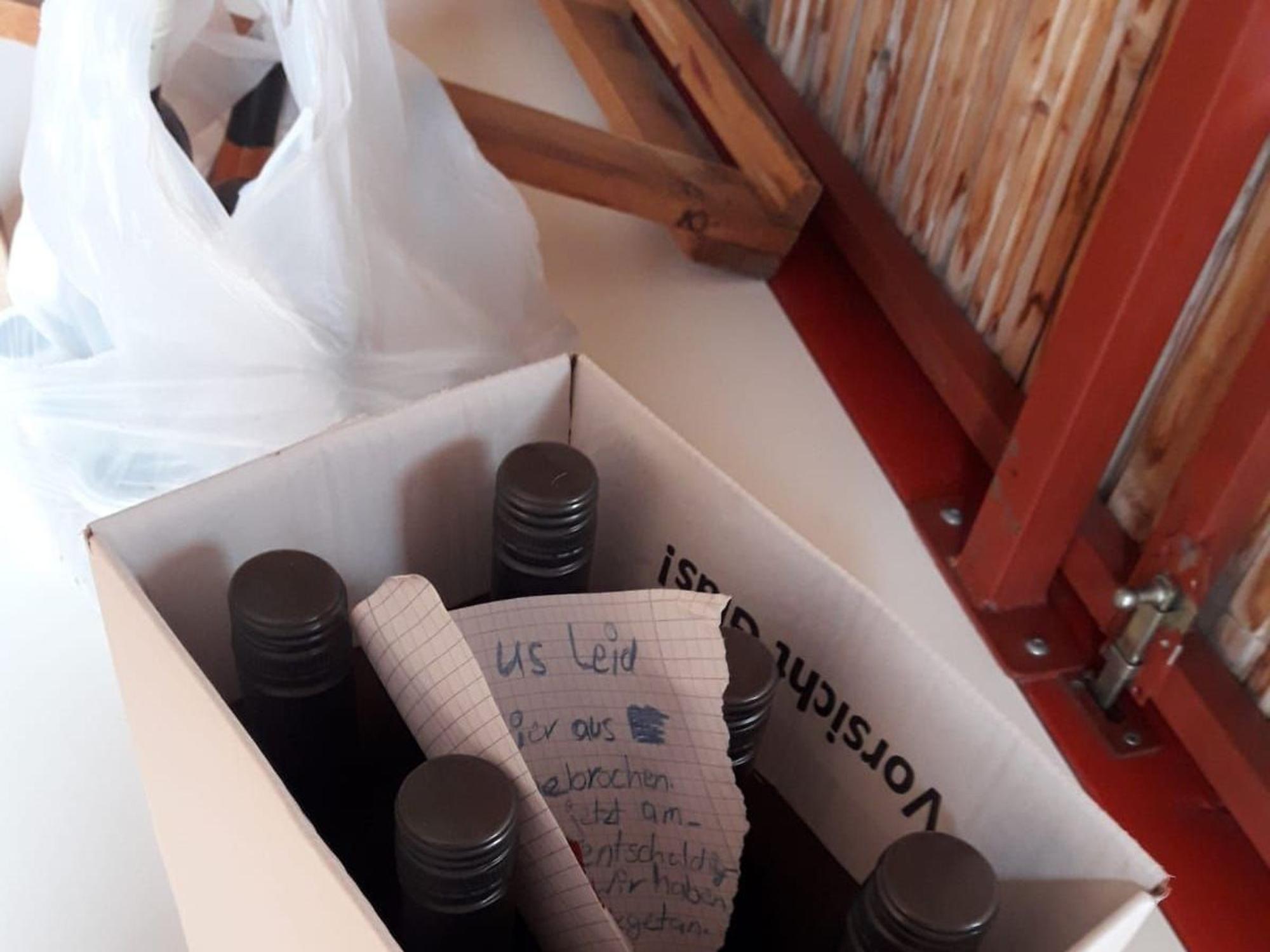 In einem Karton mit Flaschen steckt der Entschuldigungsbrief, daneben eine Plastiktüte mit Marmelade.
