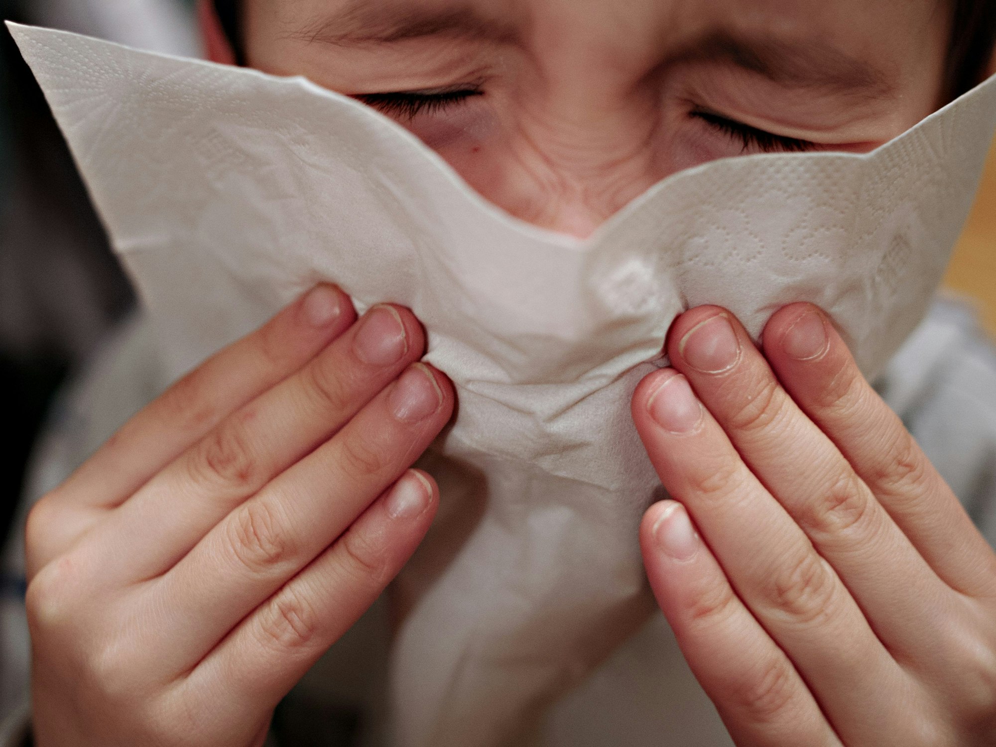 Ein kleiner Junge hält sich ein Taschentuch an die Nase. Nach den Corona-Lockerungen könnte Europa eine neue Grippewelle bevorstehen.