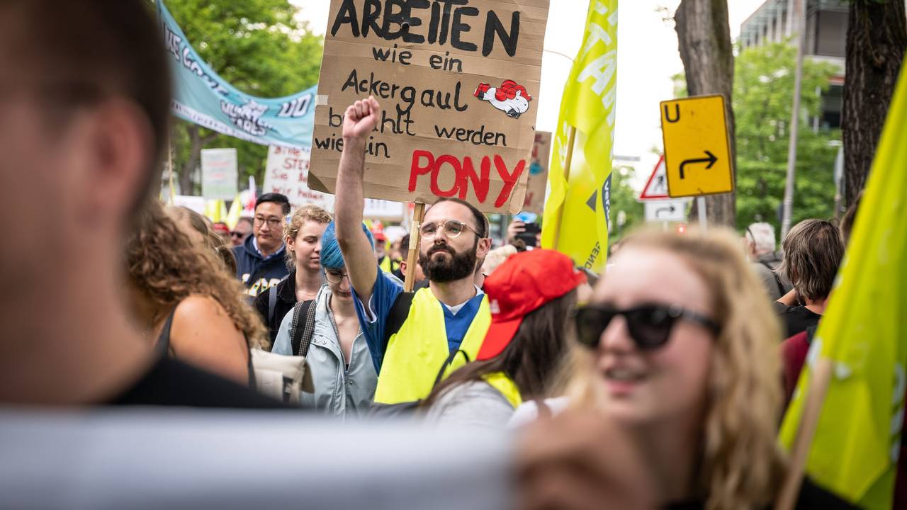 Mit einem Plakat "Arbeiten wie ein Ackergaul - bezahlt werden wie ein Pony" nehmen Pflegekräfte an einer Demonstration teil.