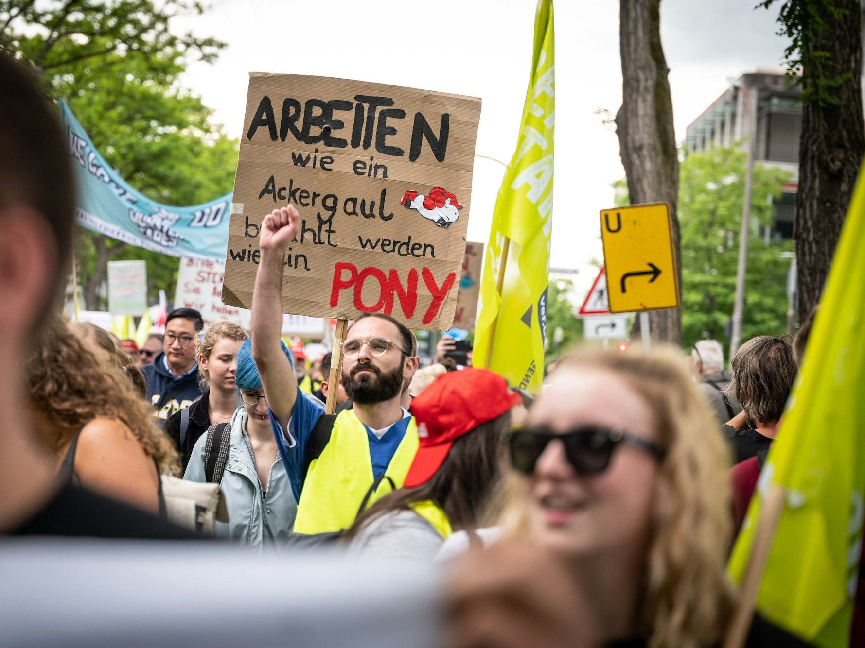 Mit einem Plakat "Arbeiten wie ein Ackergaul - bezahlt werden wie ein Pony" nehmen Pflegekräfte an einer Demonstration teil.
