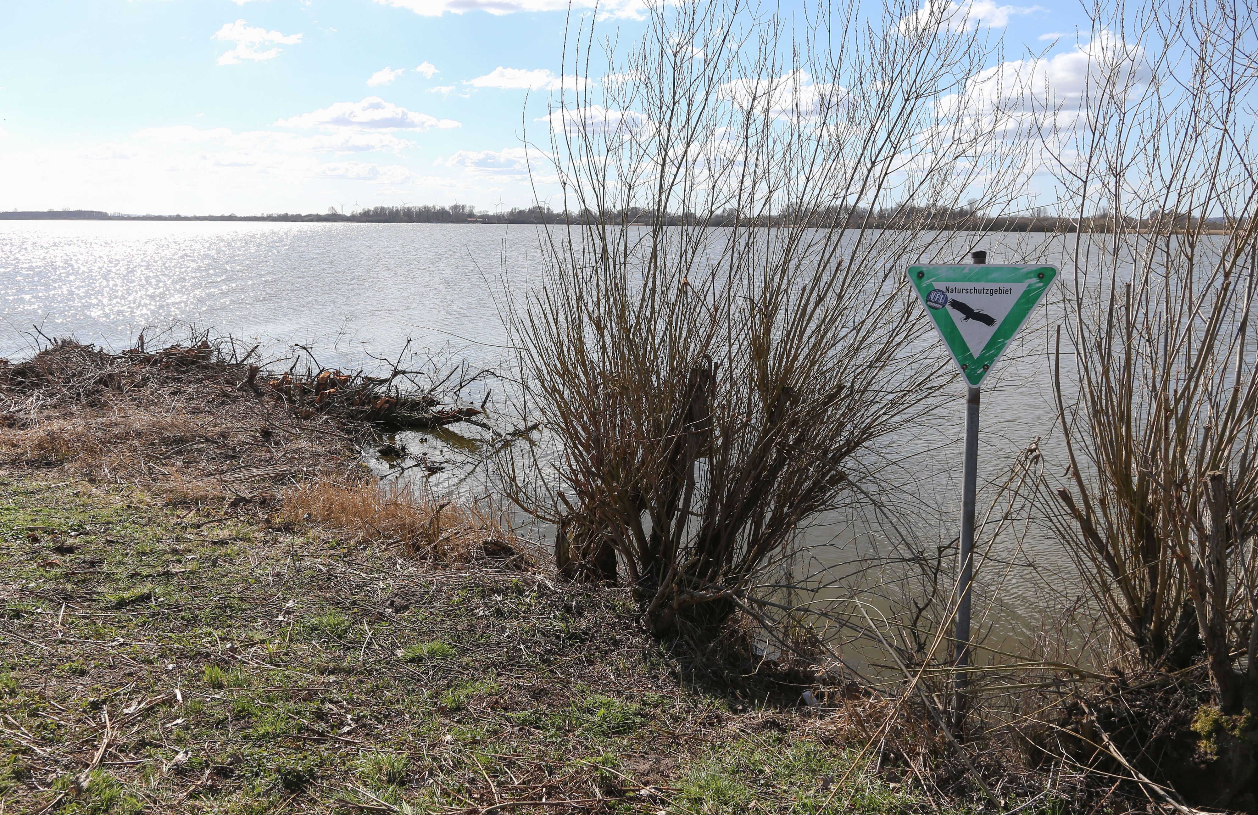 Ein Schild an einem See weist auf ein Naturschutzgebiet hin.