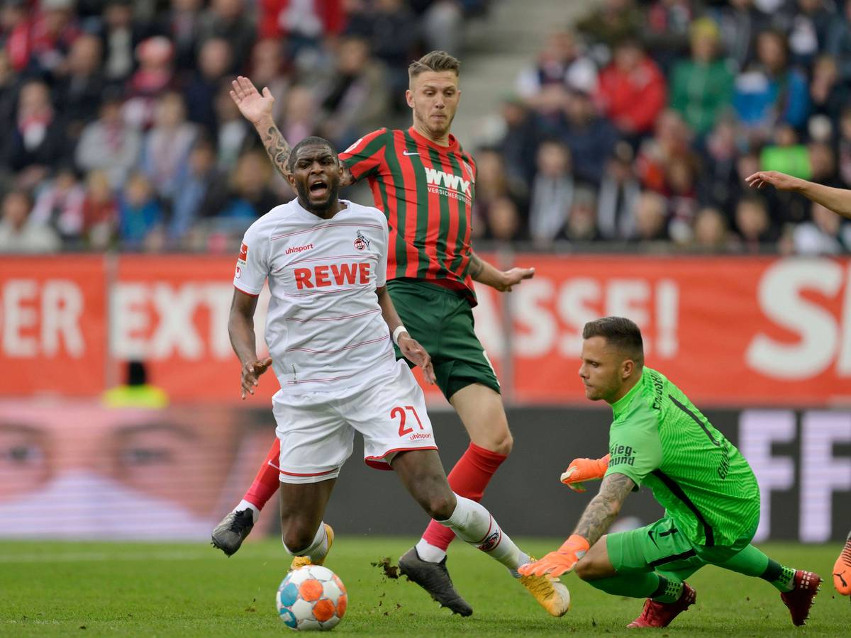 Anthony Modeste (l.) wird am 32. Spieltag von Jeffrey Gouweleeuw (m.) im Strafraum gefoult. (30. April 2022)