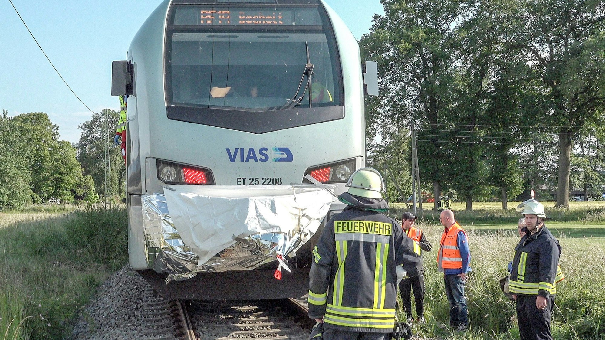 Einsatzkräfte der Feuerwehr stehen vor einem Zug. Eine Radfahrerin ist am Dienstagabend (31. Mai 2022) in Hamminkeln (Kreis Wesel) von einem Zug erfasst worden und gestorben.
