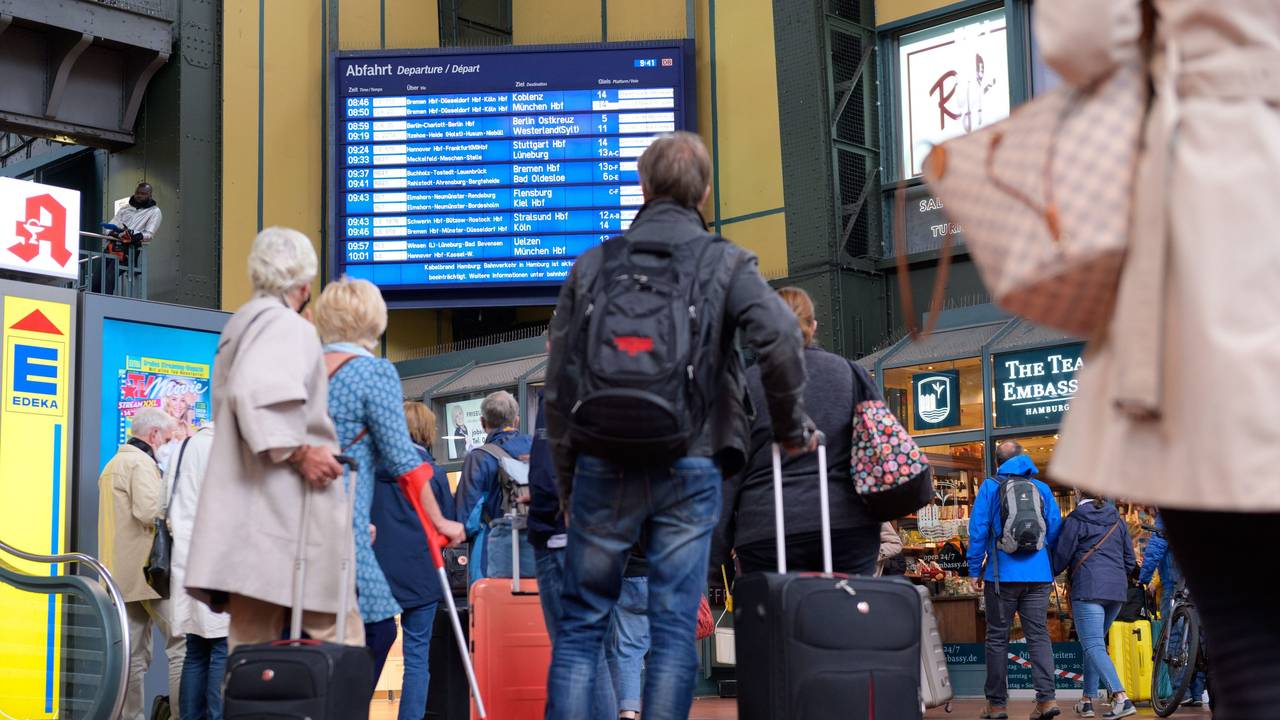 Zahlreiche Reisende vor einer Anzeigetafel mit An- und Abfahrtszeiten der Züge am Hamburger Hauptbahnhof.