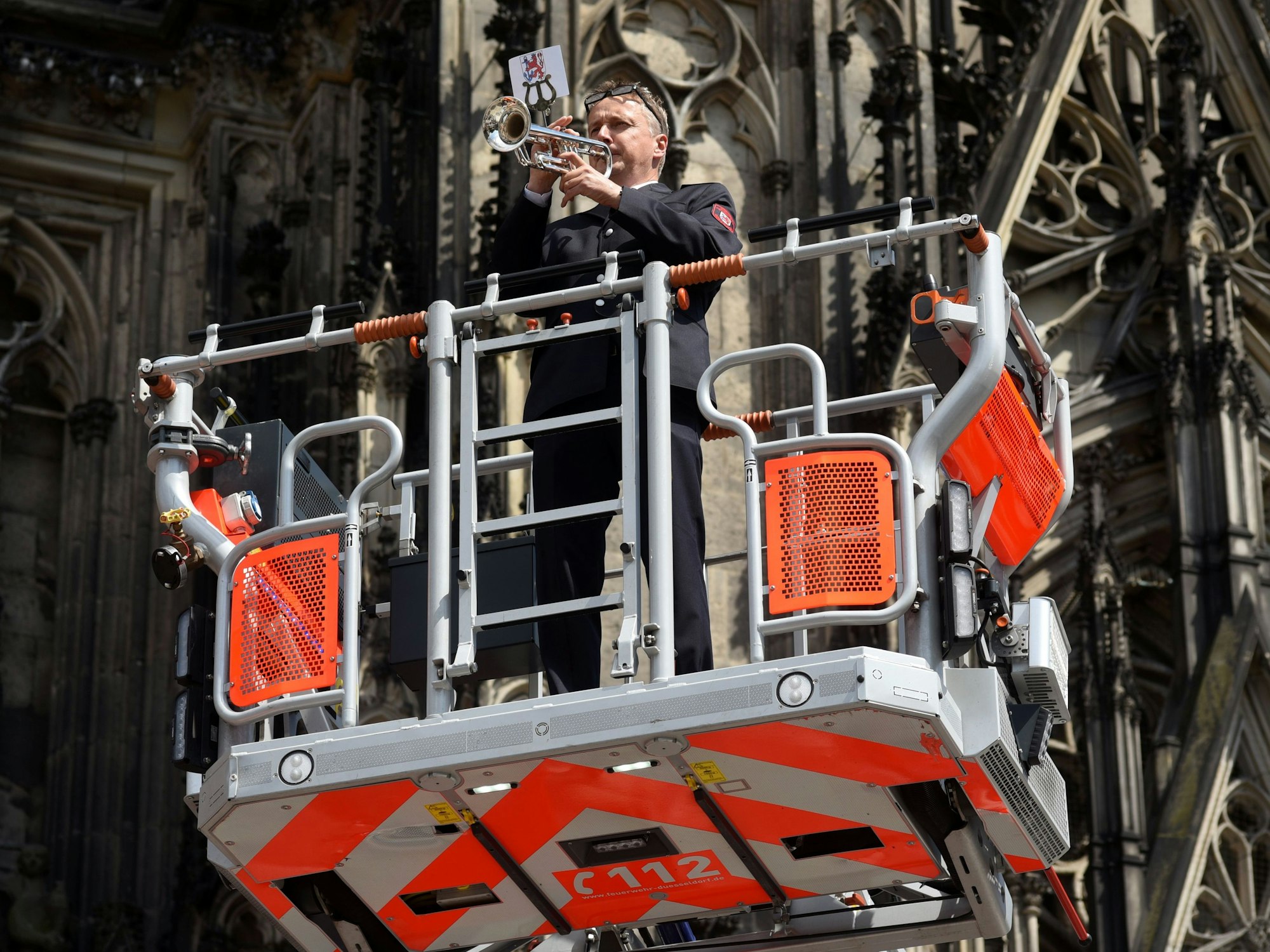02.06.2022, Köln: Die Feuerwehren Köln und Düsseldorf gratulieren sich gegenseitig jeweils zum 150-jährigen Bestehen auf der Domplatte in Köln.
Trompetenständchen von einem Düsseldorfer Feuerwehrmann
Foto: Csaba Peter Rakoczy
