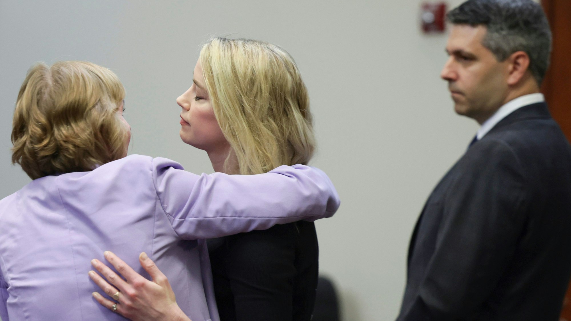 Nach der Urteilsverkündung im Prozess zwischen Johnny Depp und Amber Heard am 1. Juni 2022 wird Amber Heard von ihrer Anwältin Elaine Bredehoft getröstet, Benjamin Rottenborn schaut zu.