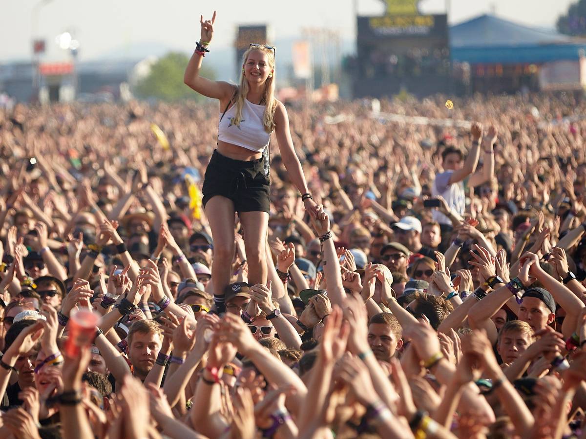 Eine junge Frau steht beim Auftritt der US-amerikanischen Punkband Rise Against vor der Hauptbühne des Musikfestival Rock am Ring auf den Schultern eines Zuschauers.