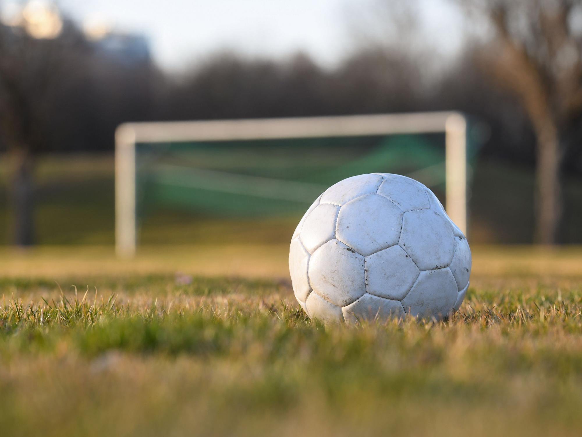 Ein Fußball liegt auf einem Fußballplatz.