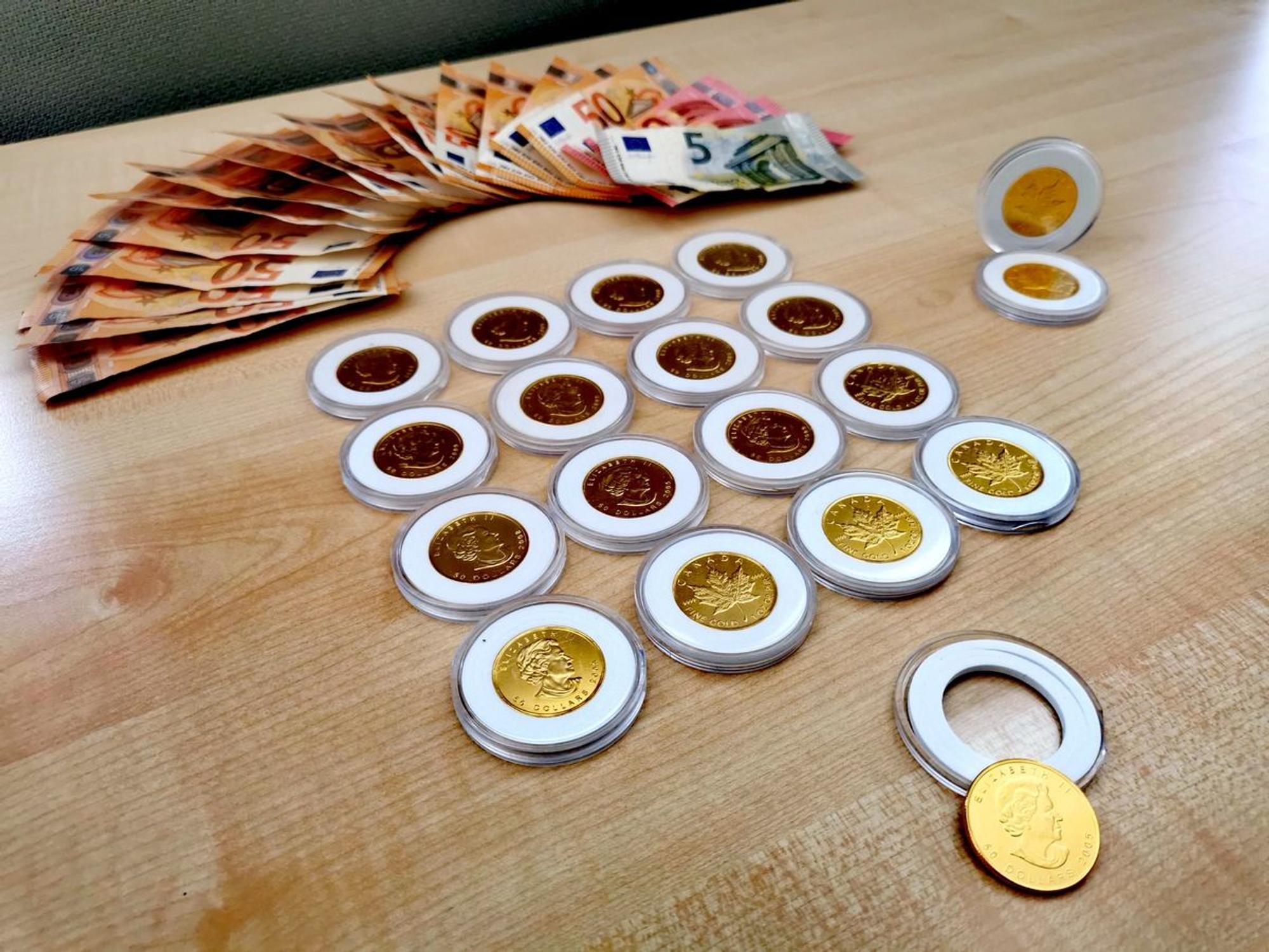 Gefälschte Goldmünzen und mehrere 100 Euro Bargeld liegen auf einem Tisch.