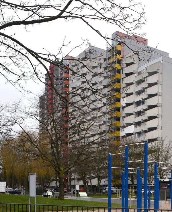 Hohe Wohnbauten in Köln-Chorweiler hinter einem Spielplatz.
