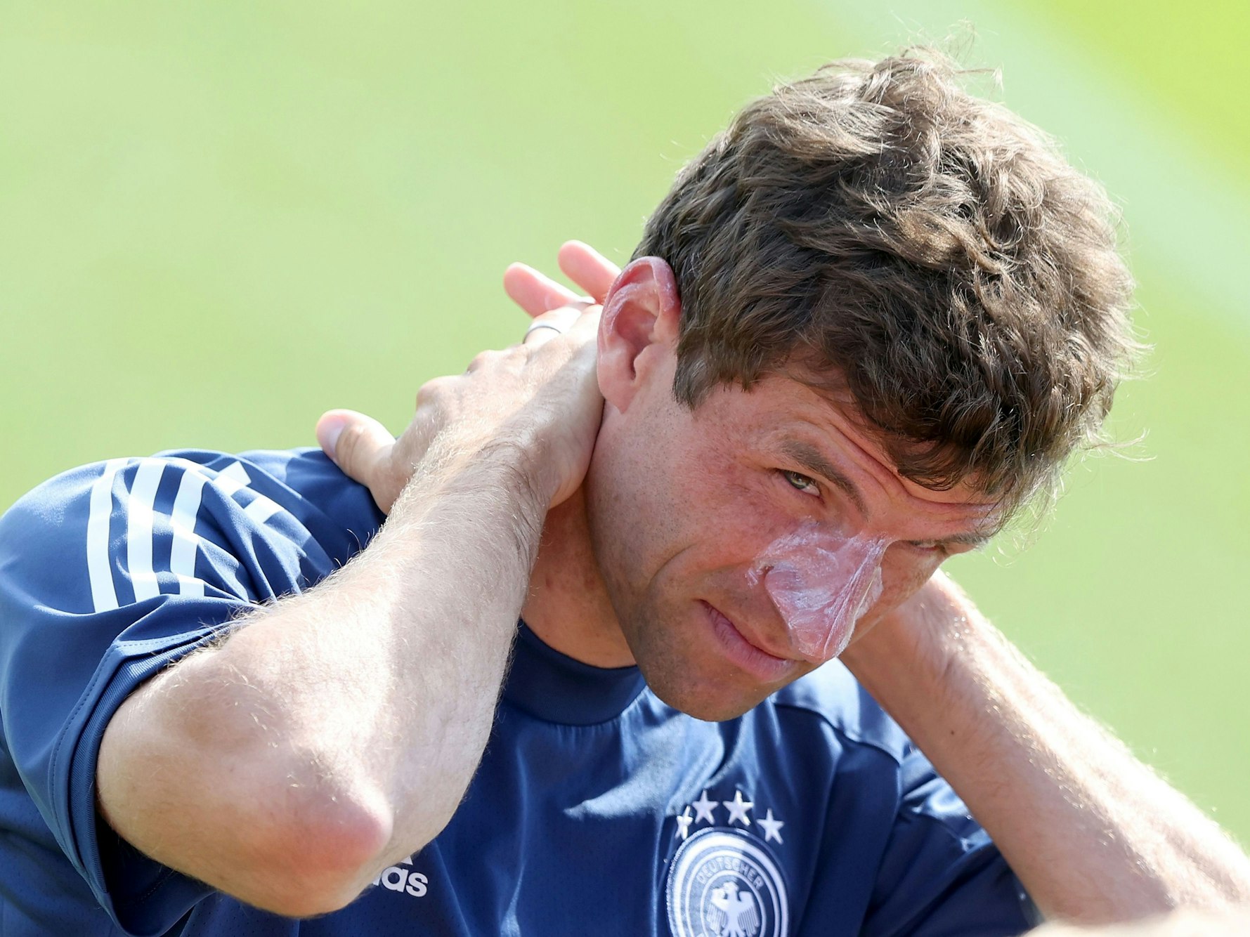 Thomas Müller schmiert sich mit Sonnencreme ein.