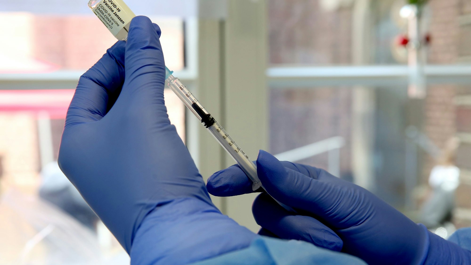 Eine Person zieht eine Spritze auf.