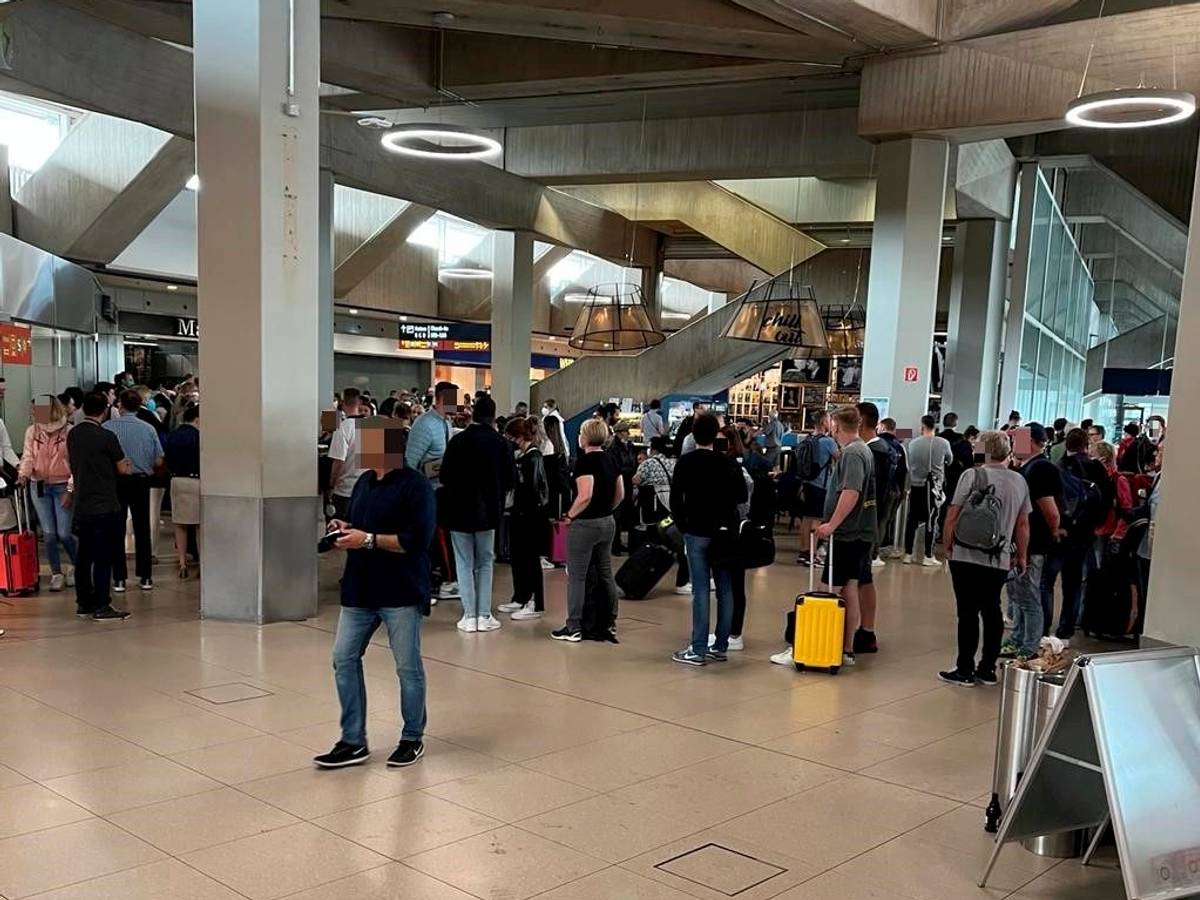 Reisende stehen am Flughafen Köln/Bonn vor der Sicherheitskontrolle Schlange.