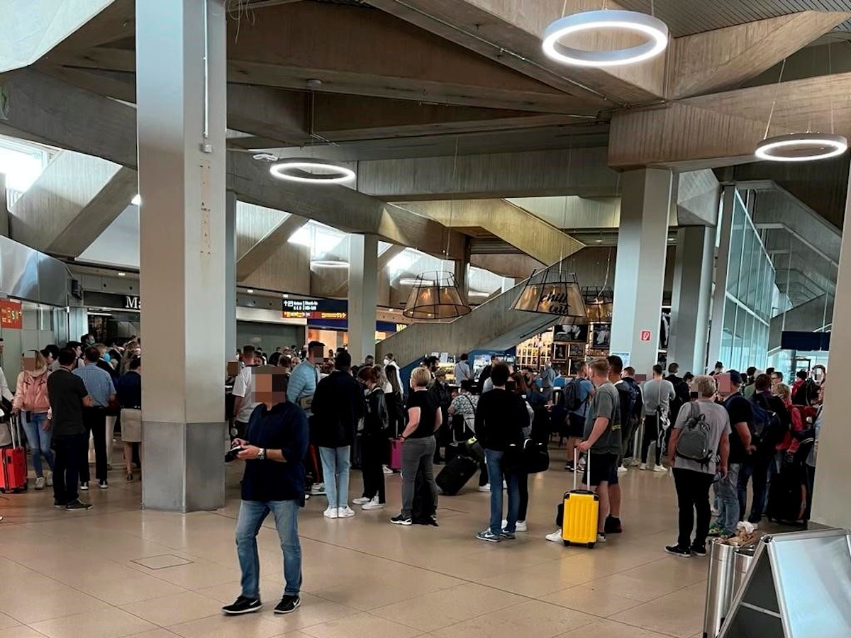 Reisende stehen am Flughafen Köln/Bonn vor der Sicherheitskontrolle Schlange.