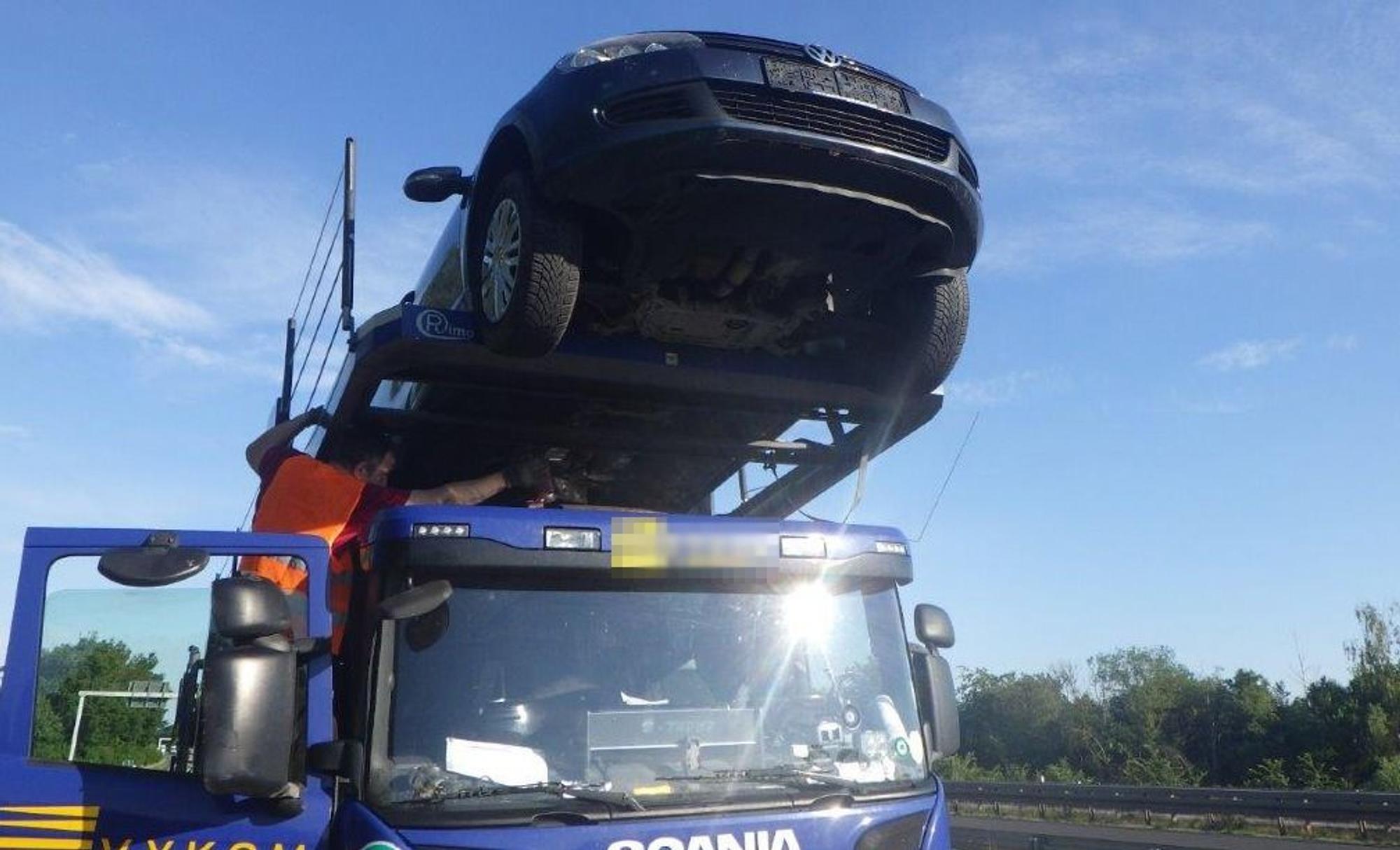 Ein Auto ragt weiter über die Fahrerkabine eines Transporters hinaus.
