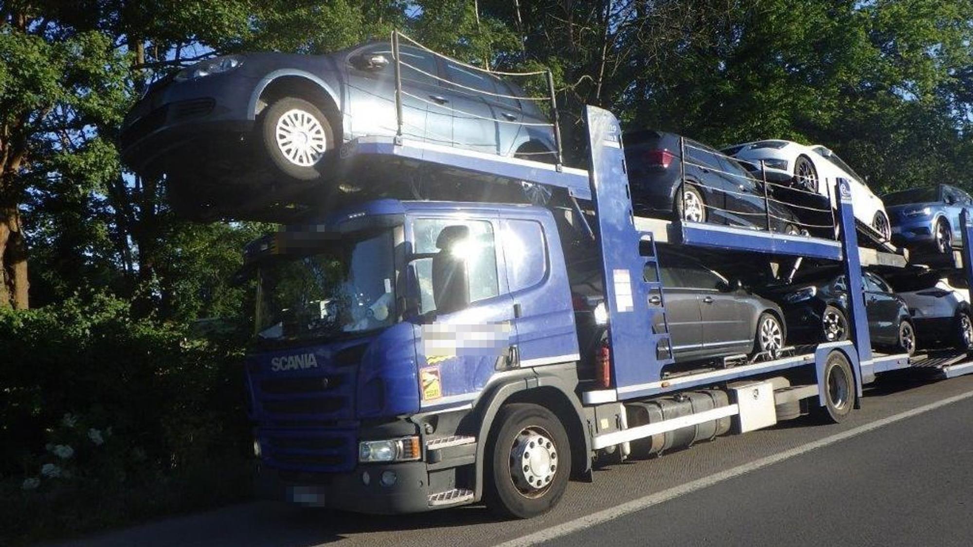 Ein Auto ragt mit seinen Vorderreifen über die Fahrerkabine des Autotransporters hinaus.
