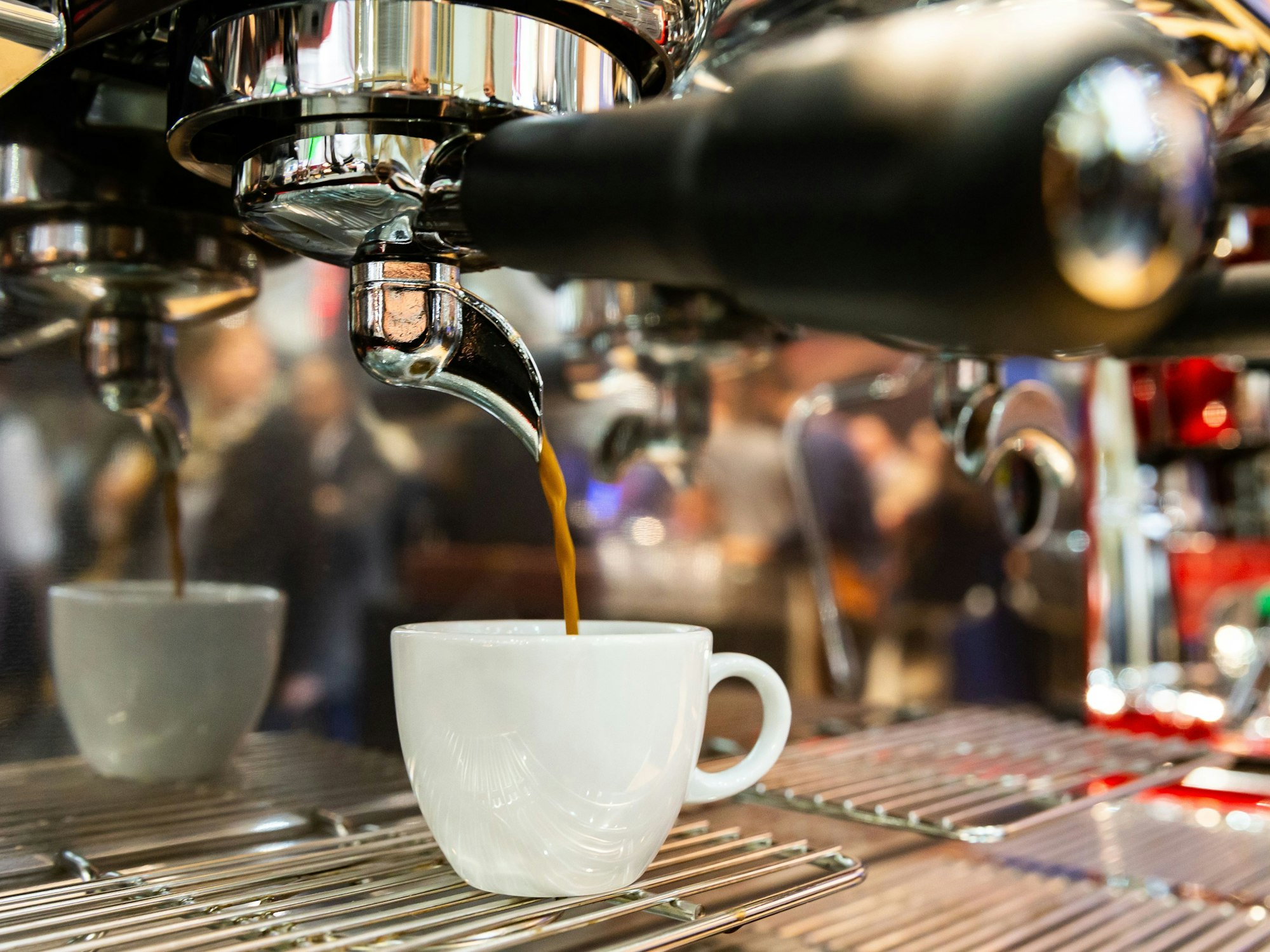 Ein Espresso läuft aus einer Espressomaschine in eine Tasse.