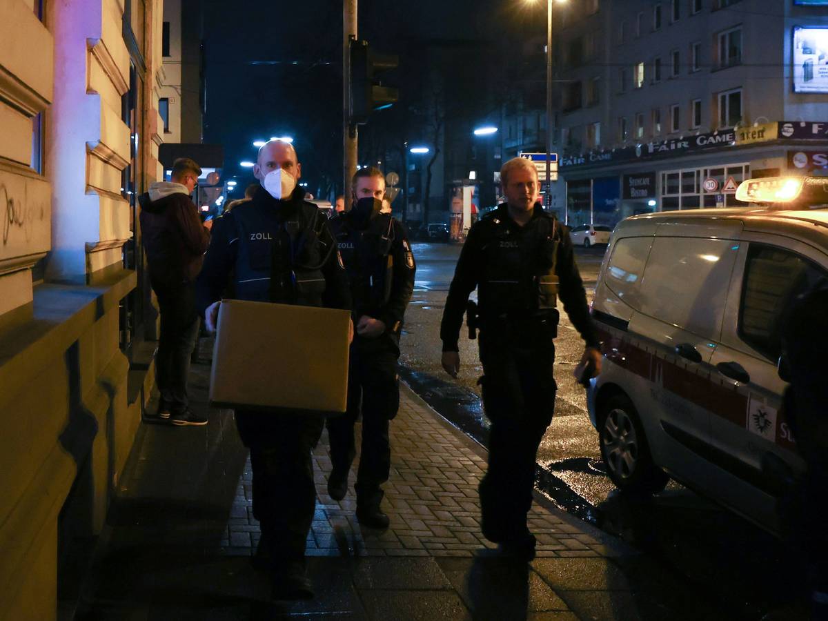 Zoll-Beamte gehen mit sichergestellten Kisten durch die Straße.