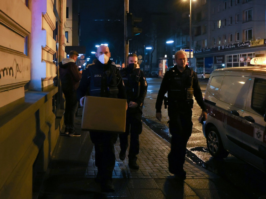 Zoll-Beamte gehen mit sichergestellten Kisten durch die Straße.