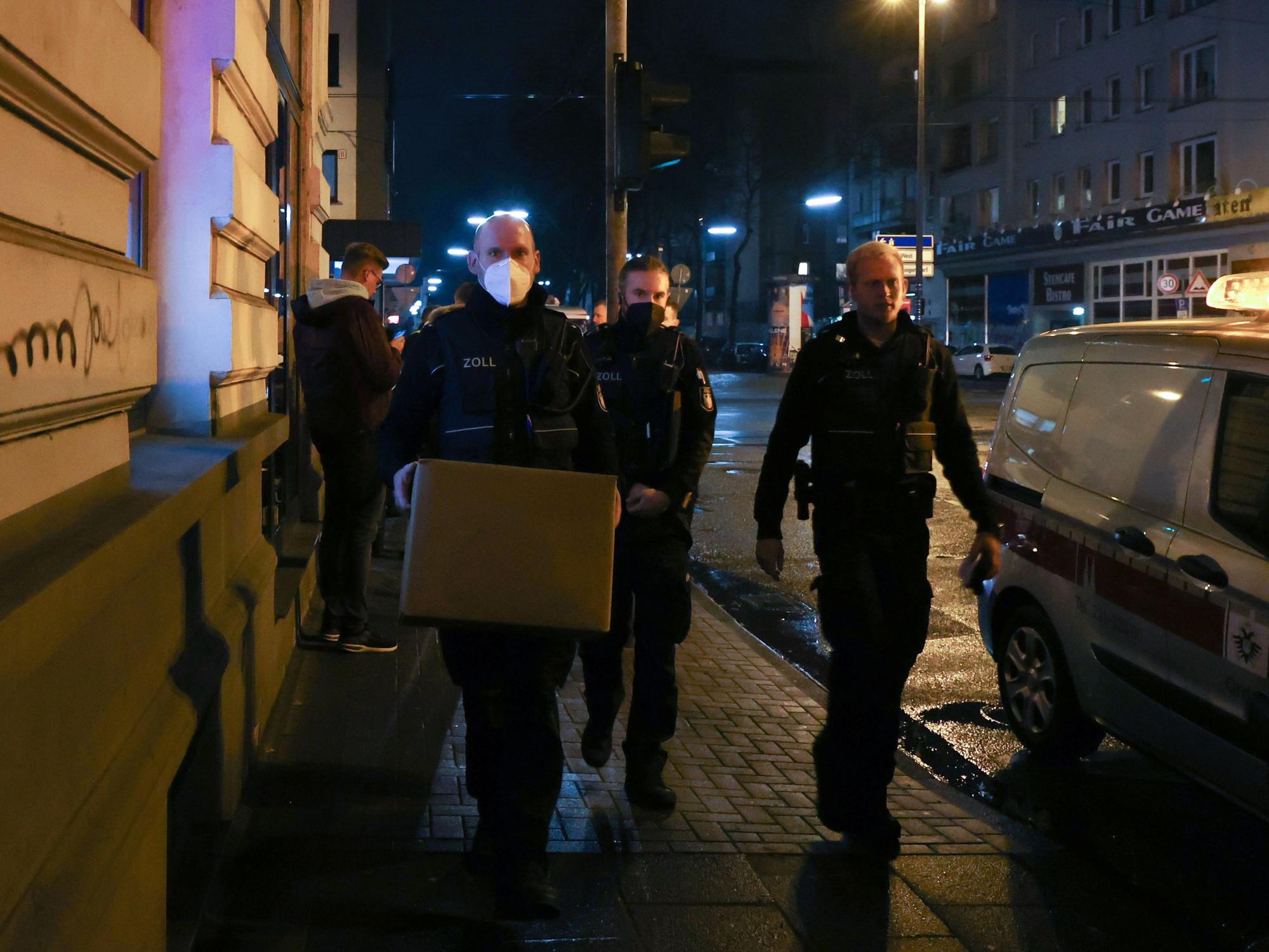 Zoll-Beamte gehen mit sichergestellten Kisten durch die Straße.