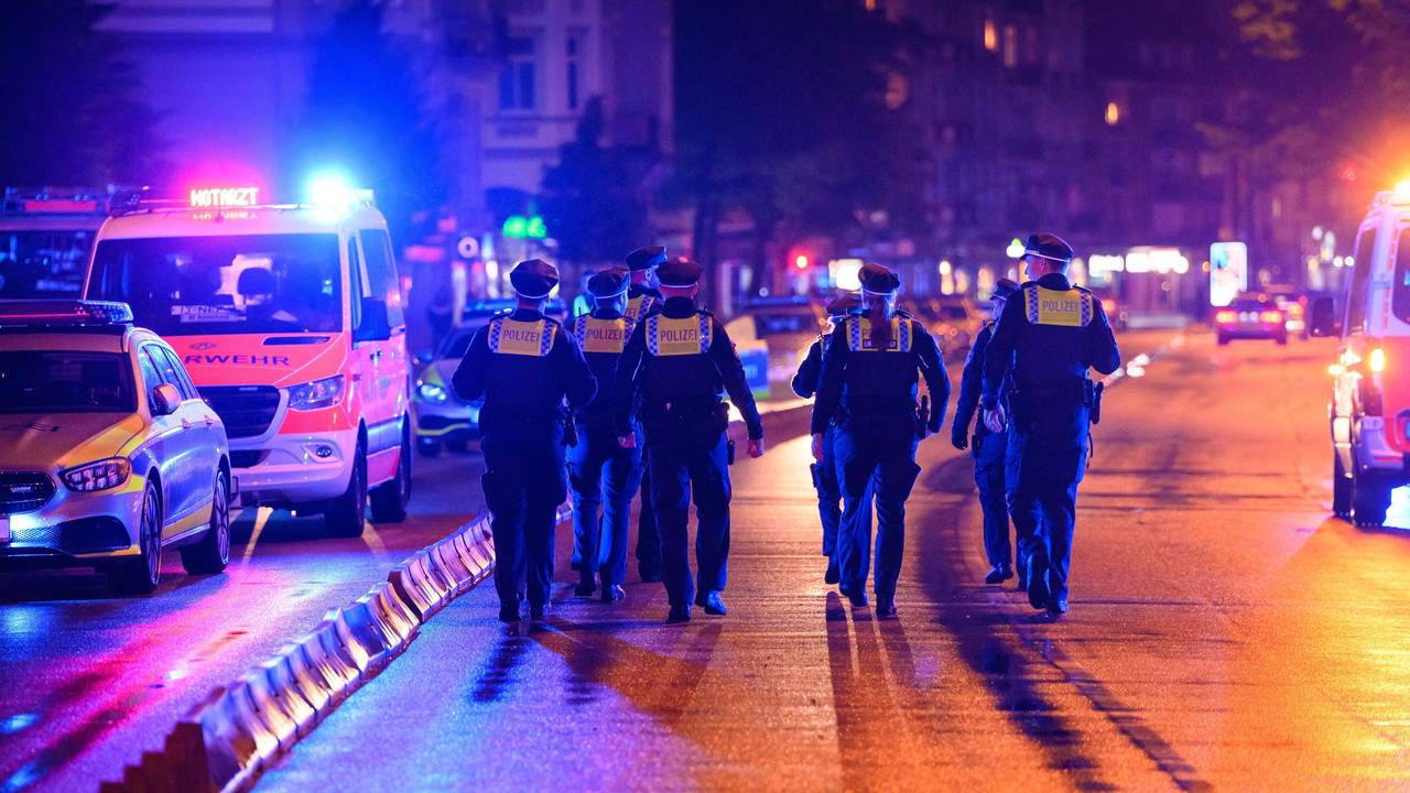 Polizeikräfte laufen zu ihren Streifenwagen.