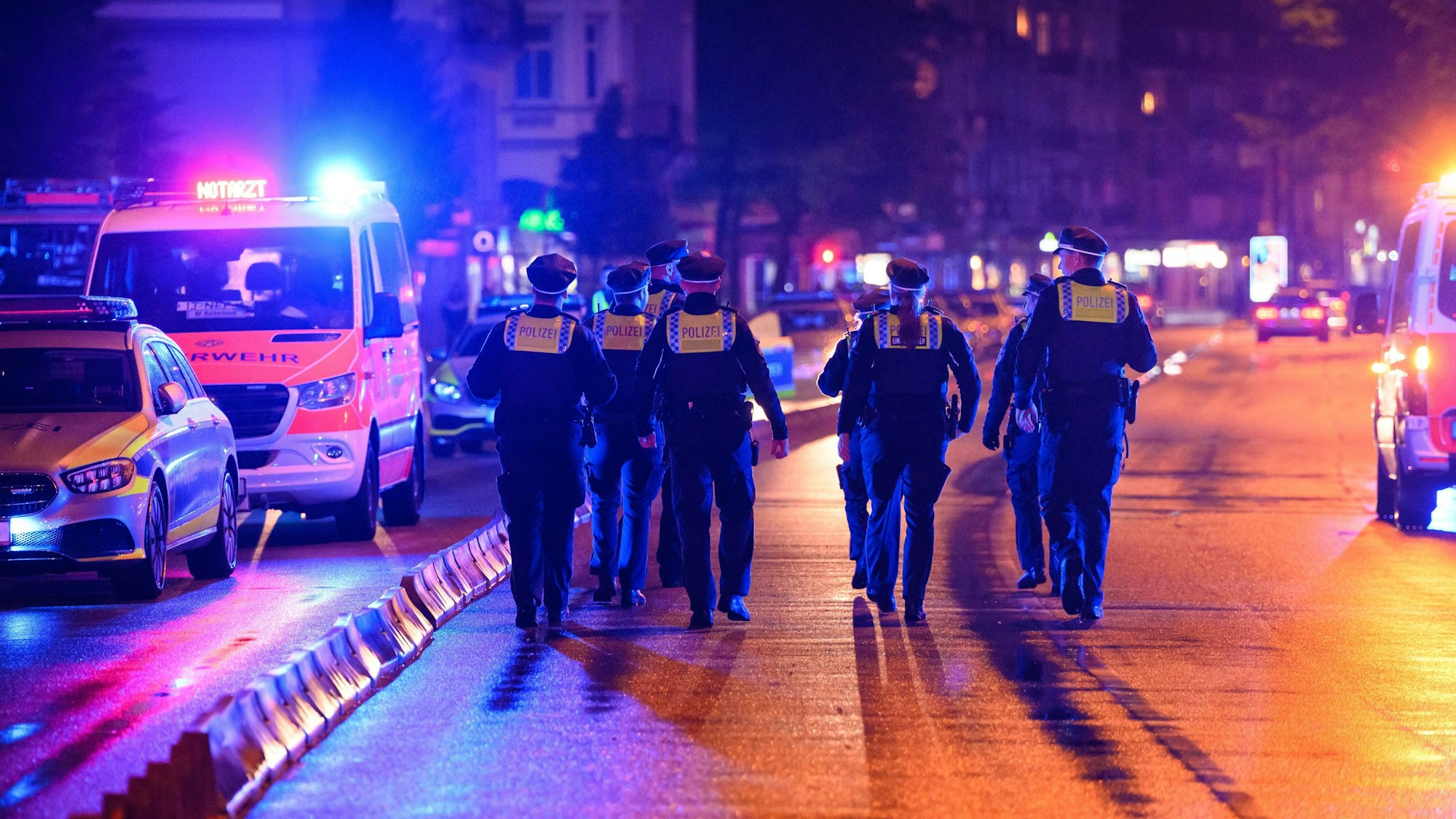 Polizeikräfte laufen zu ihren Streifenwagen.