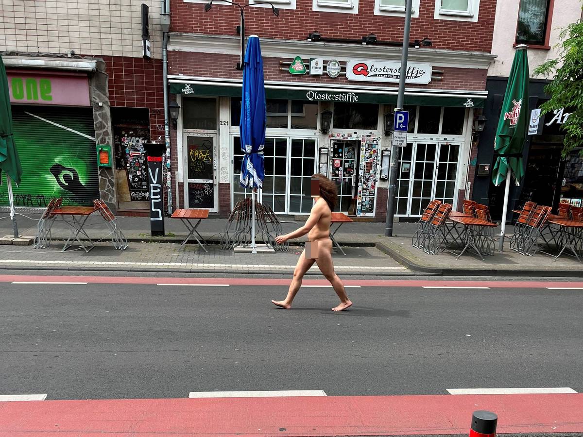 Mann geht nackt über die Venloer Straße in Köln.