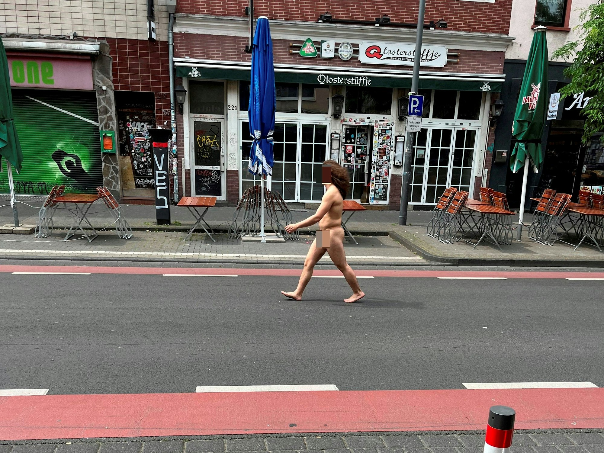 Mann geht nackt über die Venloer Straße in Köln.