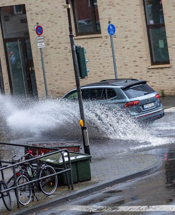 Autos fahren nach einem Starkregenschauer am Samstag (5. Juni 2022) durch das Wasser, das sich auf der Kölner Straße „Sülzgürtel“ angesammelt hat.