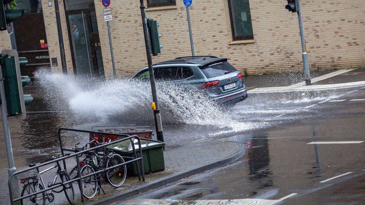 Autos fahren nach einem Starkregenschauer am Samstag (5. Juni 2022) durch das Wasser, das sich auf der Kölner Straße „Sülzgürtel“ angesammelt hat.