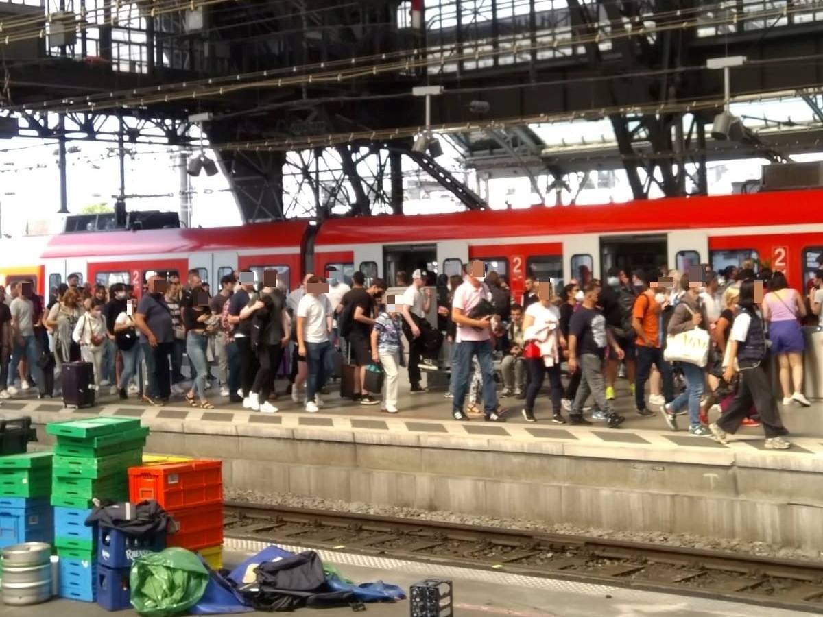 Zahlreiche Menschen auf einem vollen Bahnsteig in Köln.