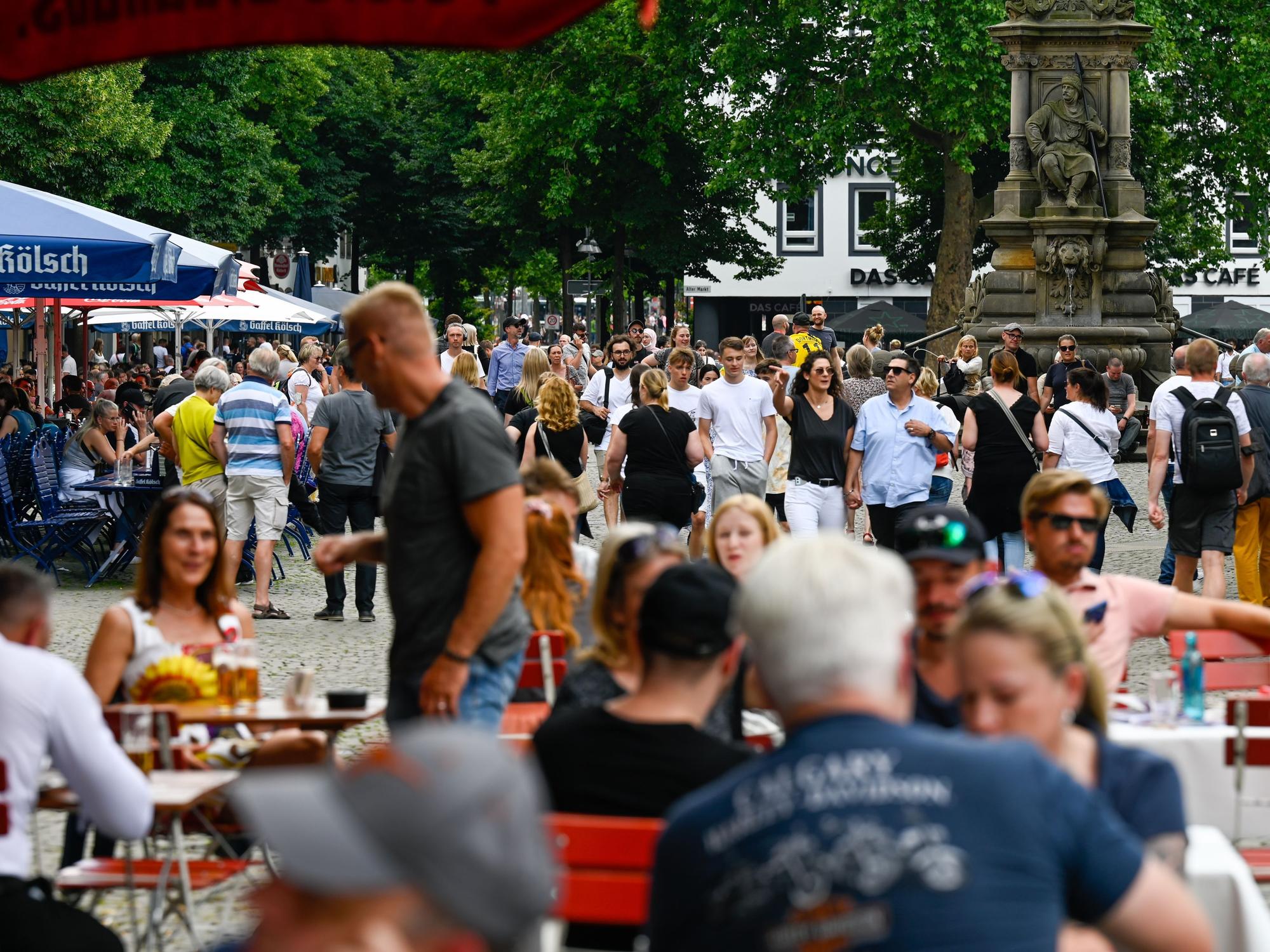 Menschen sitzen bei schönem Wetter in Gastro-Betrieben in der Kölner Altstadt.