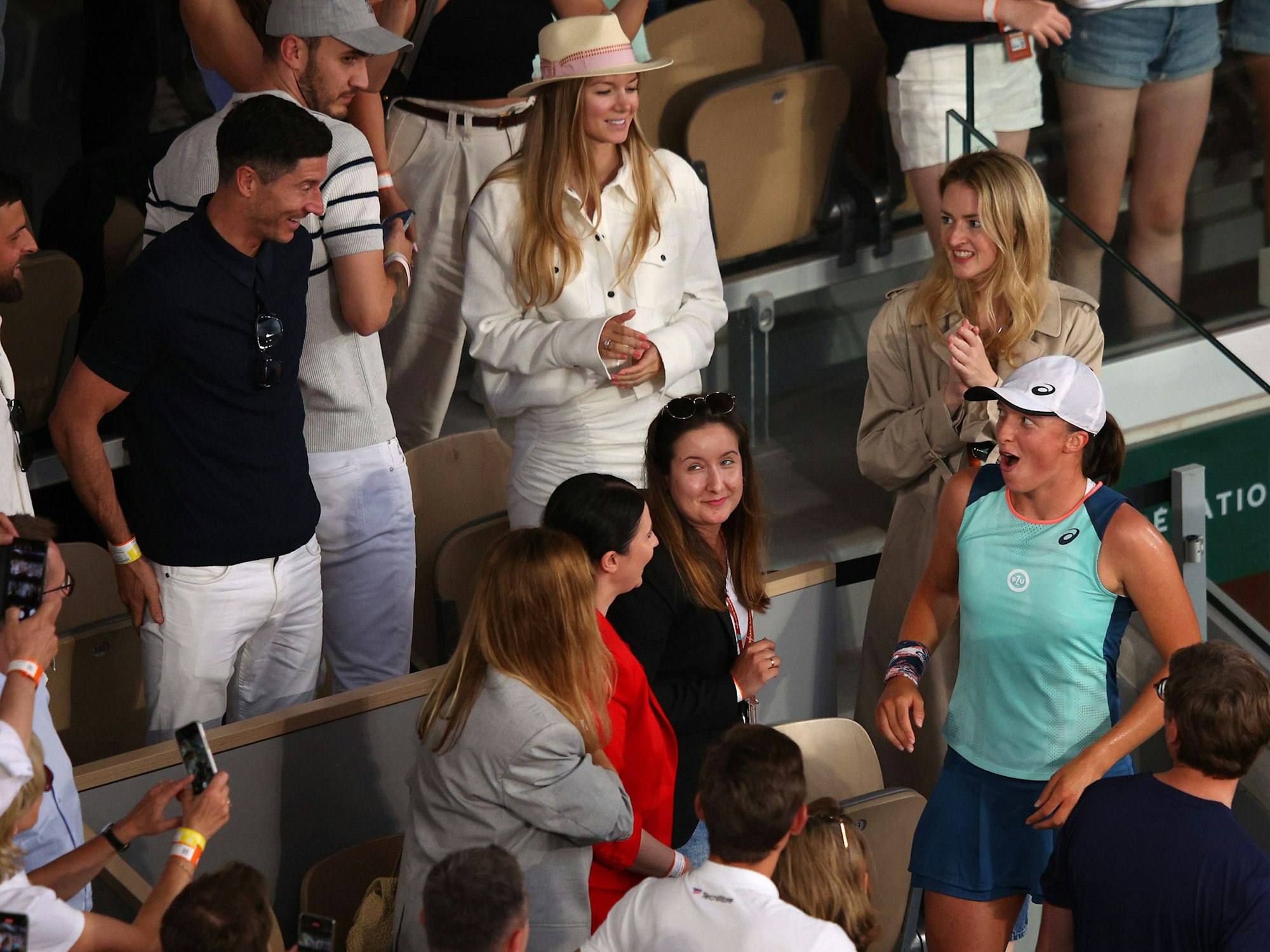 Iga Swiatek bleibt der Mund offen stehen, als sie Fußball-Star Robert Lewandwoski unter den Zuschauenden entdeckt.