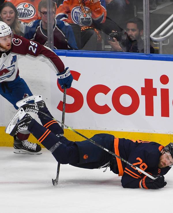 Nathan MacKinnon foult Oilers-Superstar Leon Draisaitl, der sinnbildlich auf die Nase fällt.
