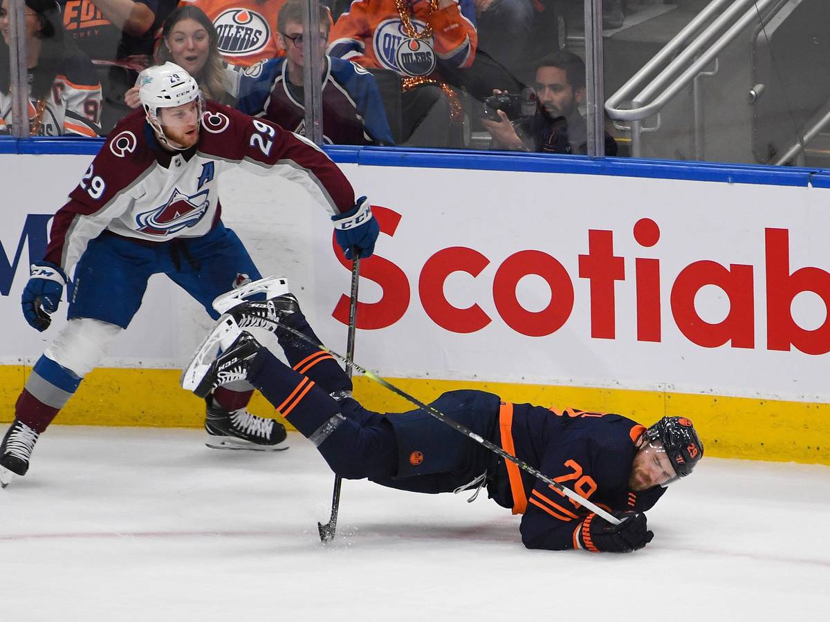 Nathan MacKinnon foult Oilers-Superstar Leon Draisaitl, der sinnbildlich auf die Nase fällt.