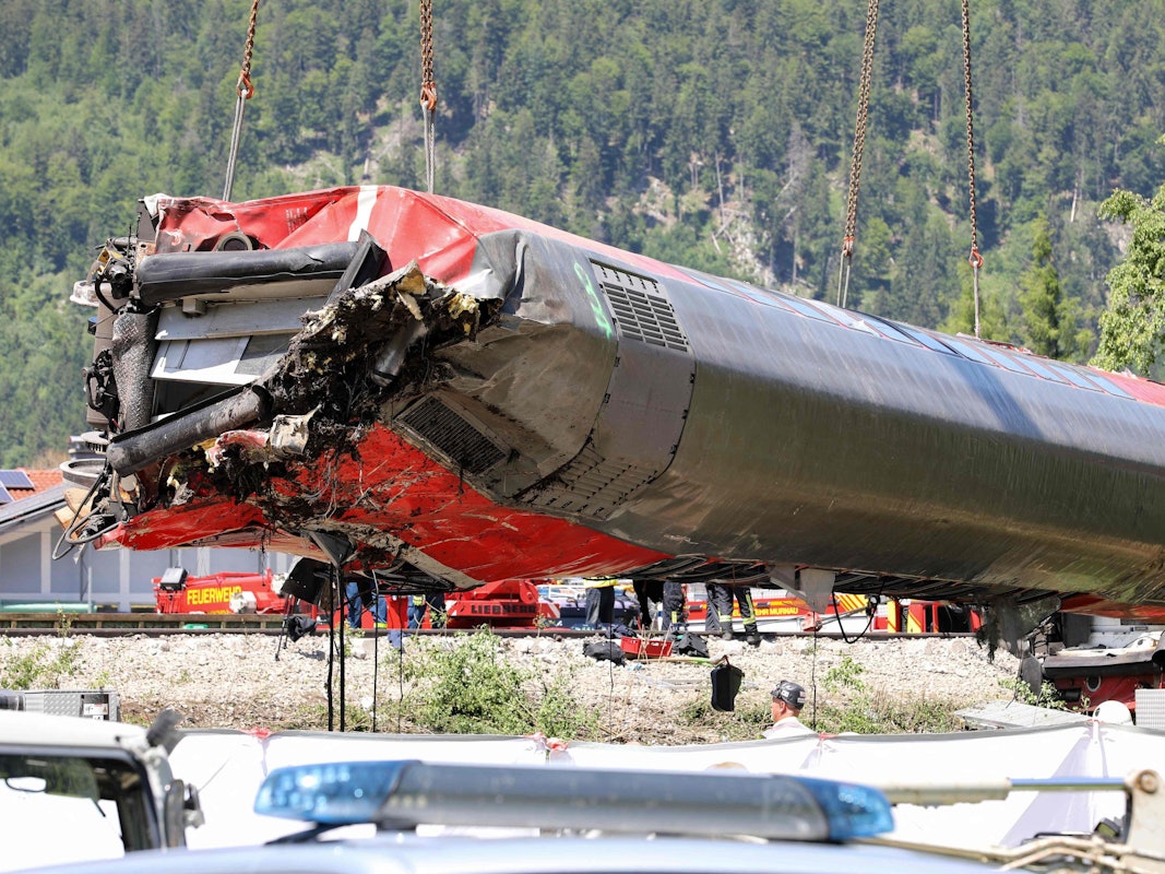Arbeiter bergen am 4. Juni, einen Tag nach dem Unfall, den tonnenschweren Waggon am Unglücksort in Garmisch-Partenkirchen mit einem Kran. Die Identifizierung der fünf Todesopfer ist weitgehend abgeschlossen.