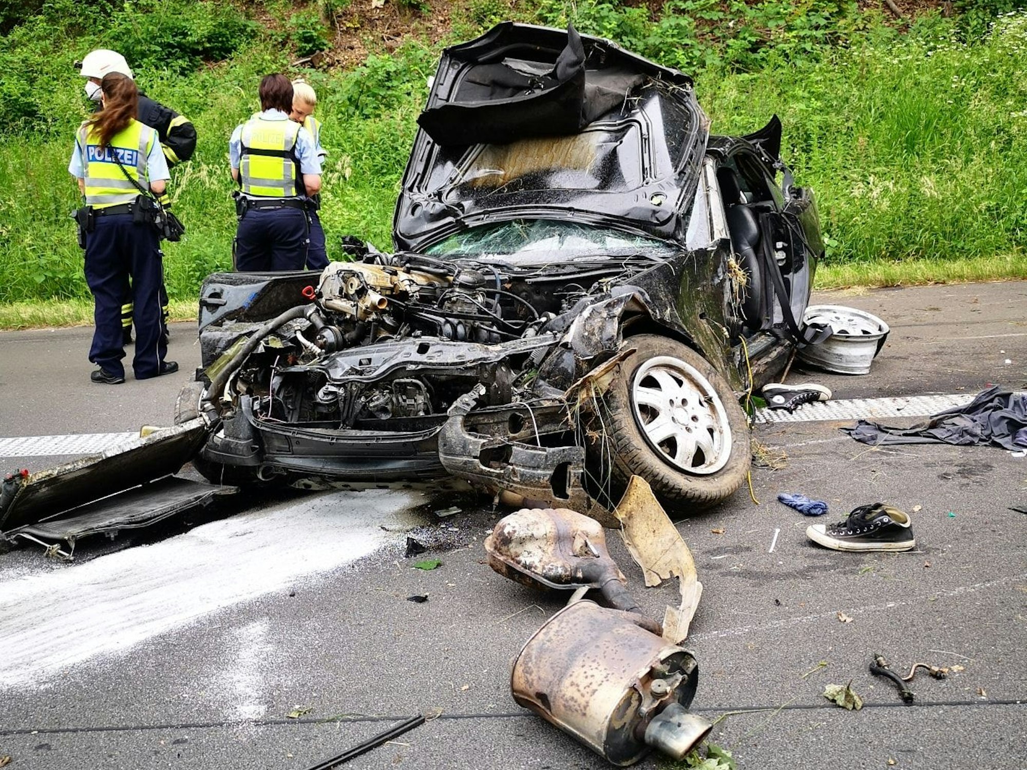 Das zerfetzte Wrack eines Mercedes SL liegt auf der Autobahn, überall liegen Trümmerteile.